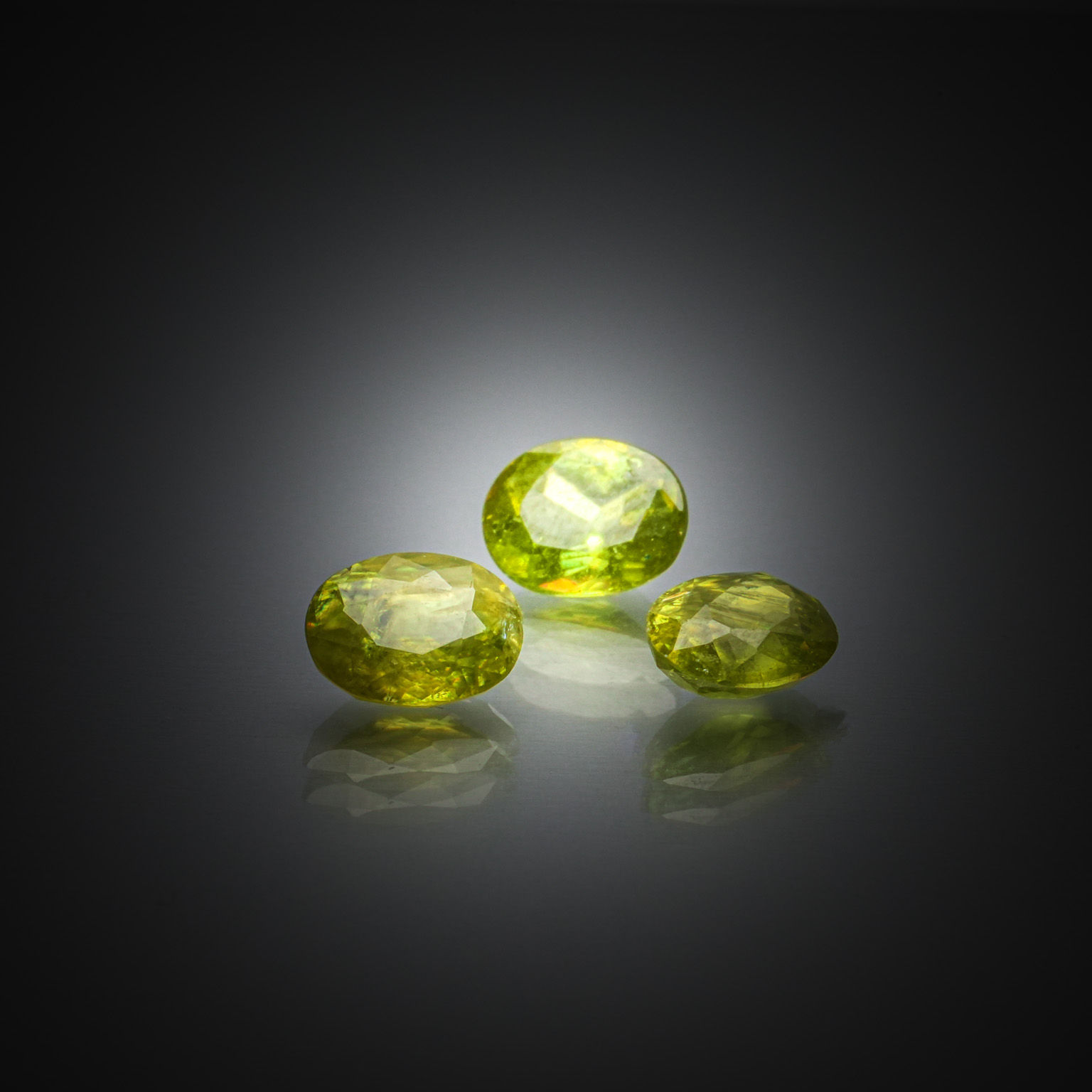 Lot de saphirs verts ronds sur papier. - Lazuli