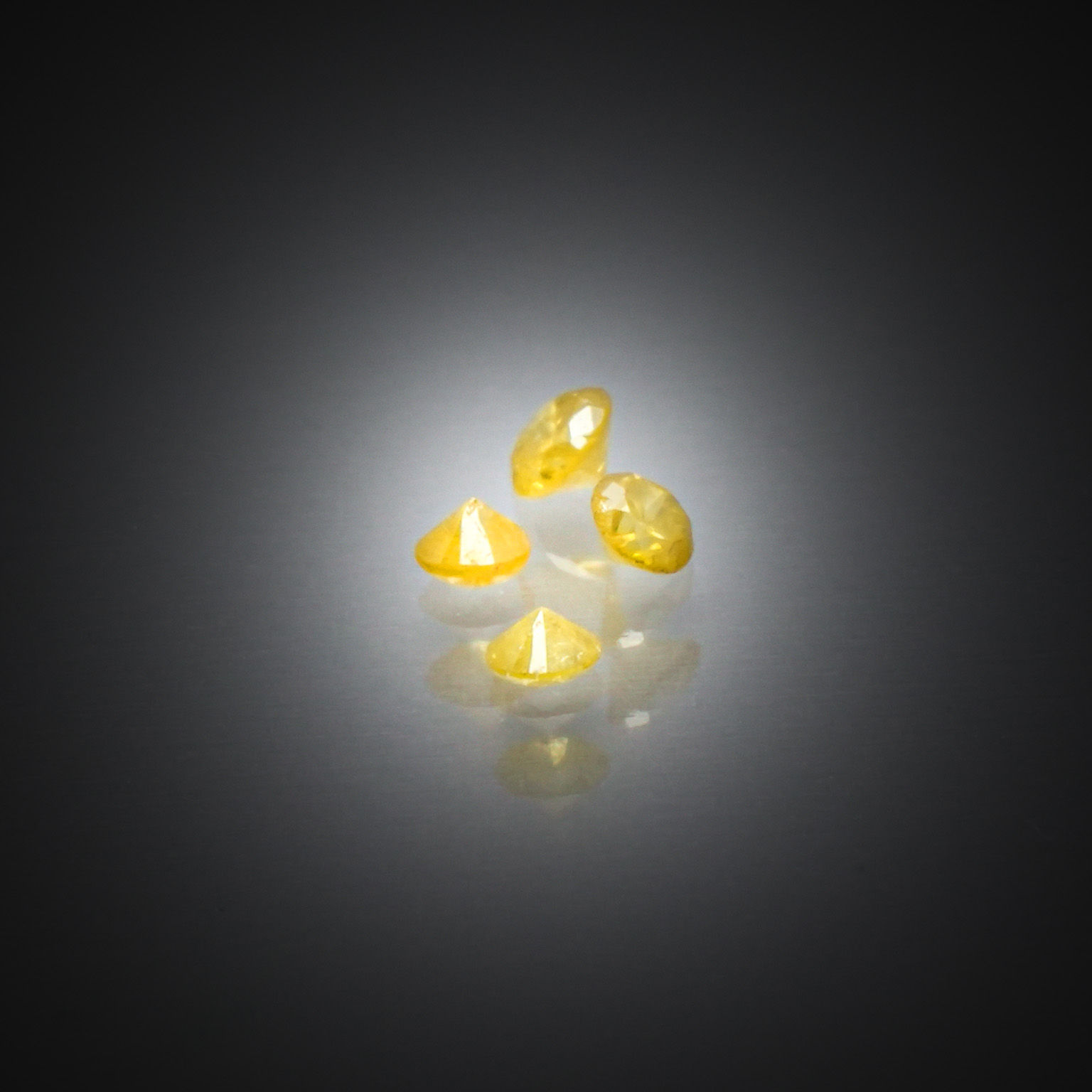 Lot de quatre diamants jaunes ronds sur papier. - Lazuli