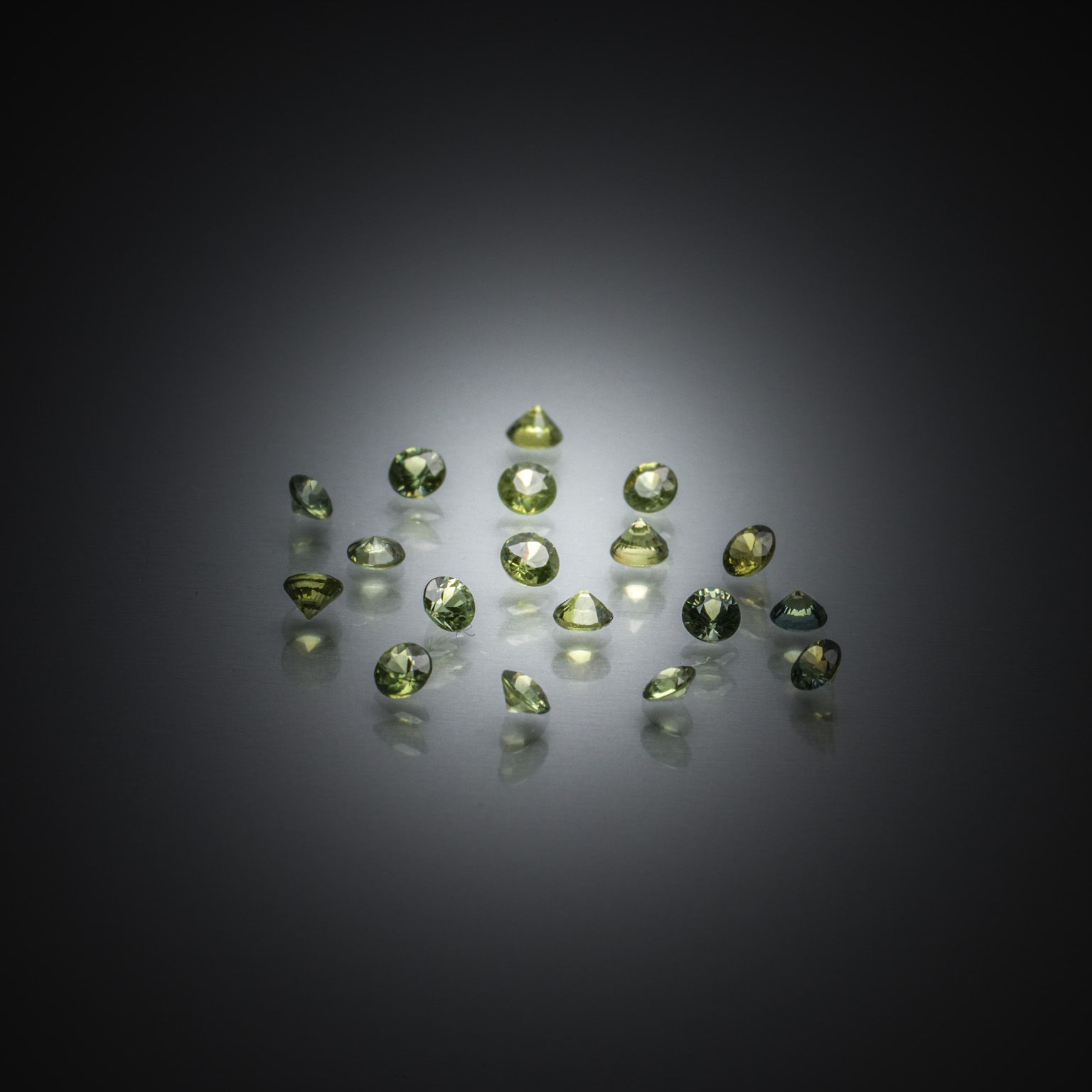 Lot de saphirs verts ronds sur papier. - Lazuli