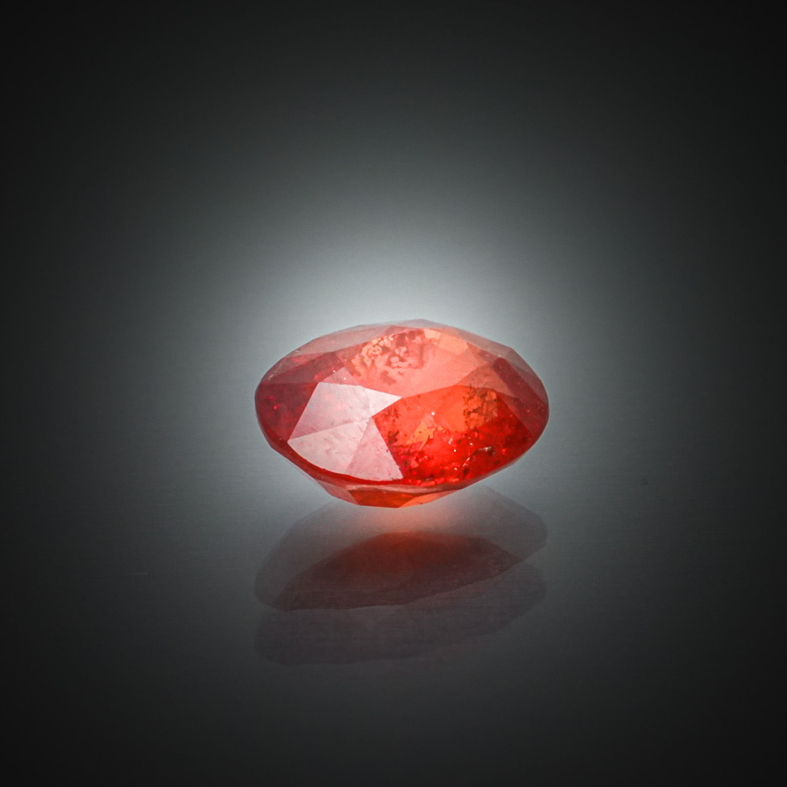 Saphir rouge/orange ovale sur papier. - Lazuli