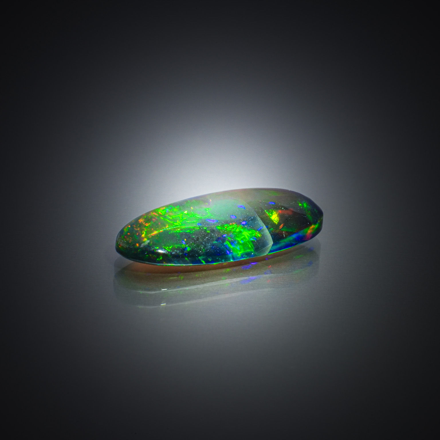 Opale noire ovale cabochon sur papier. - Lazuli
