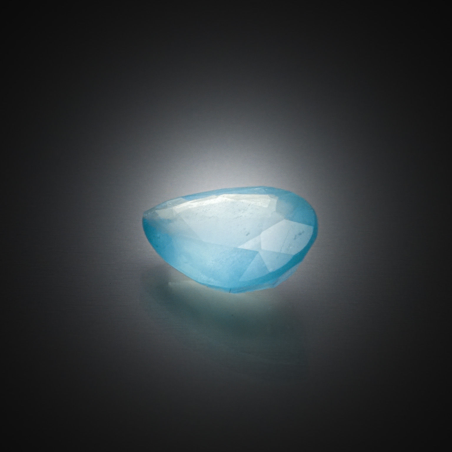 Saphir vert ovale sur papier. - Lazuli