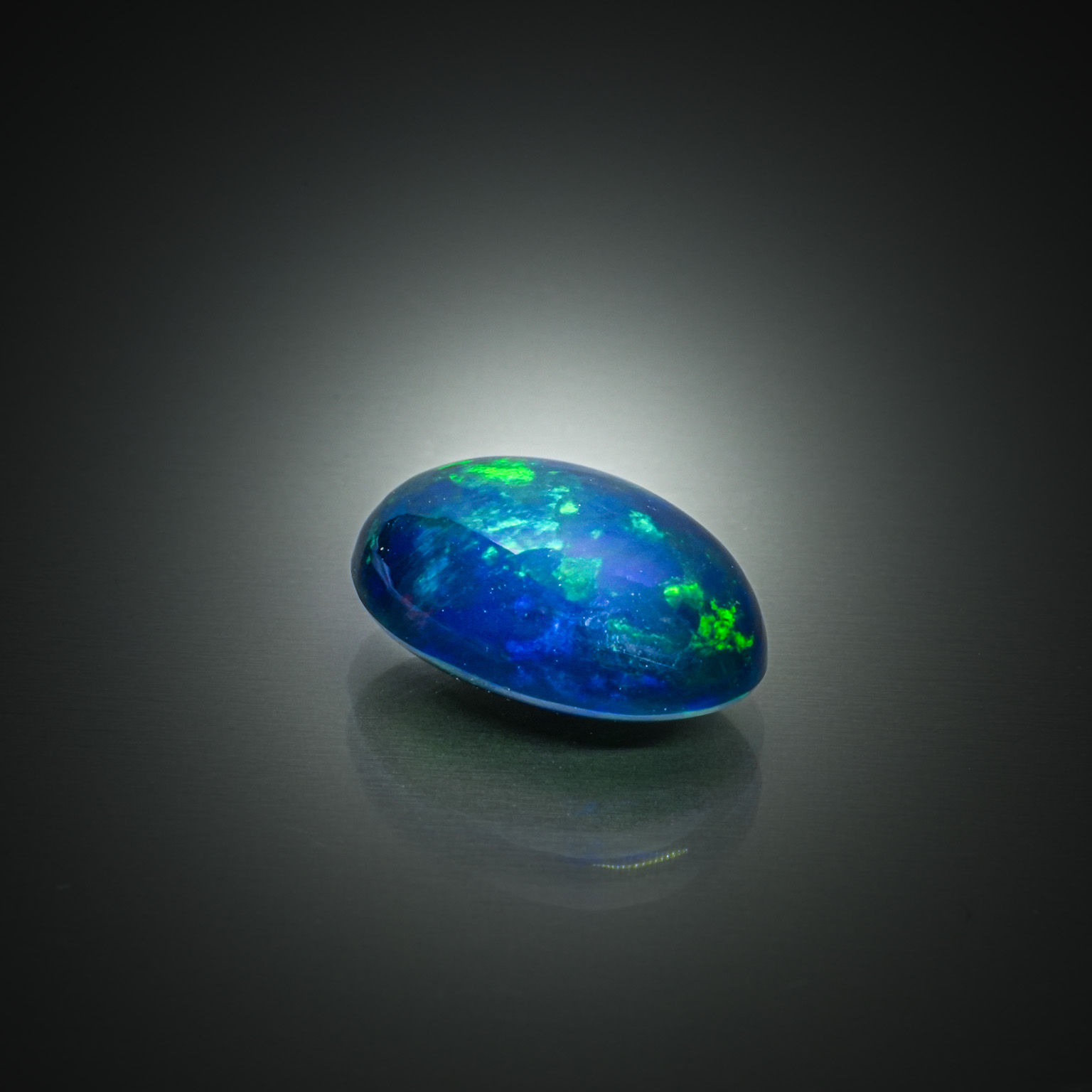 Opale noire ovale cabochon sur papier. - Lazuli