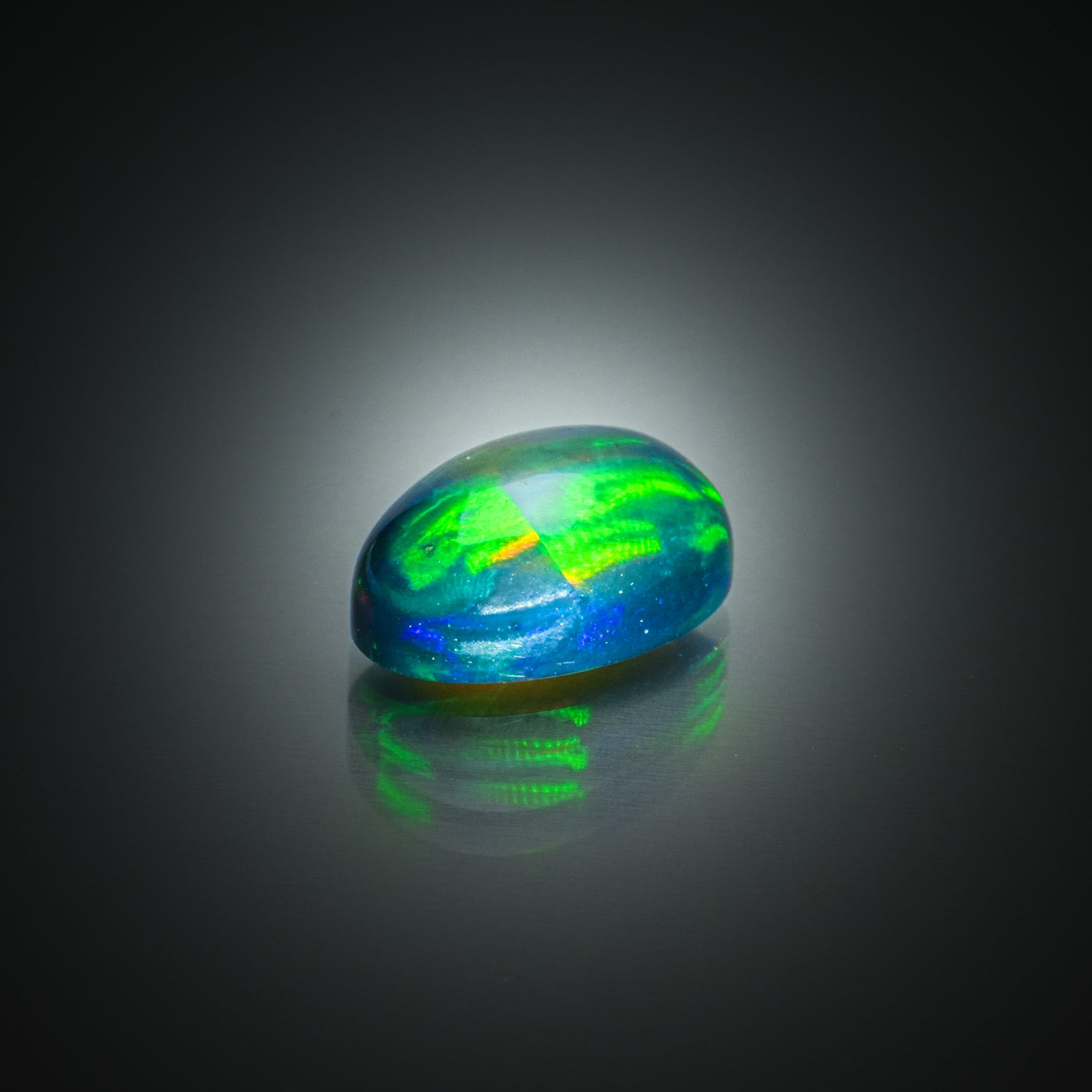 Opale noire ovale cabochon sur papier. - Lazuli