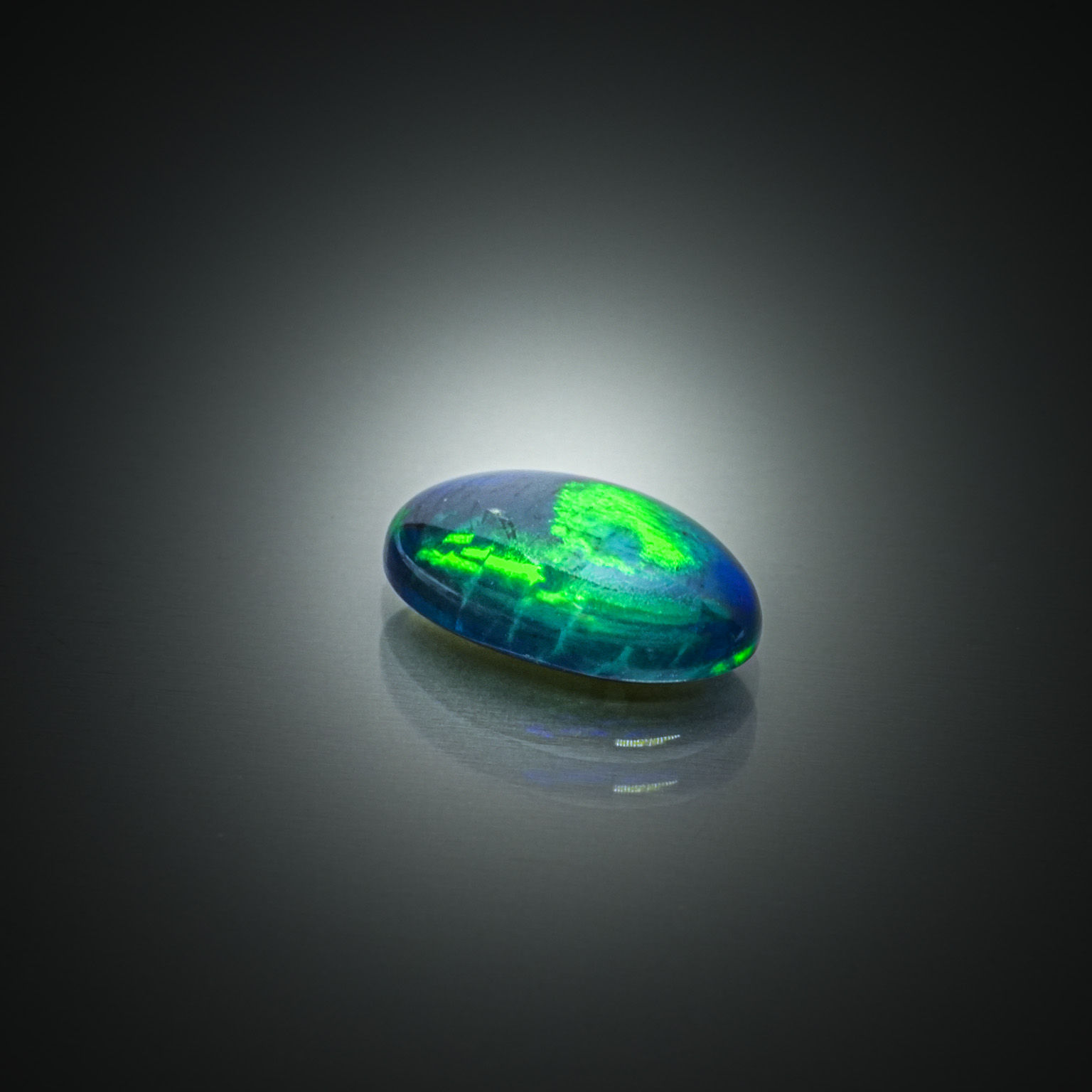Opale noire ovale cabochon sur papier. - Lazuli
