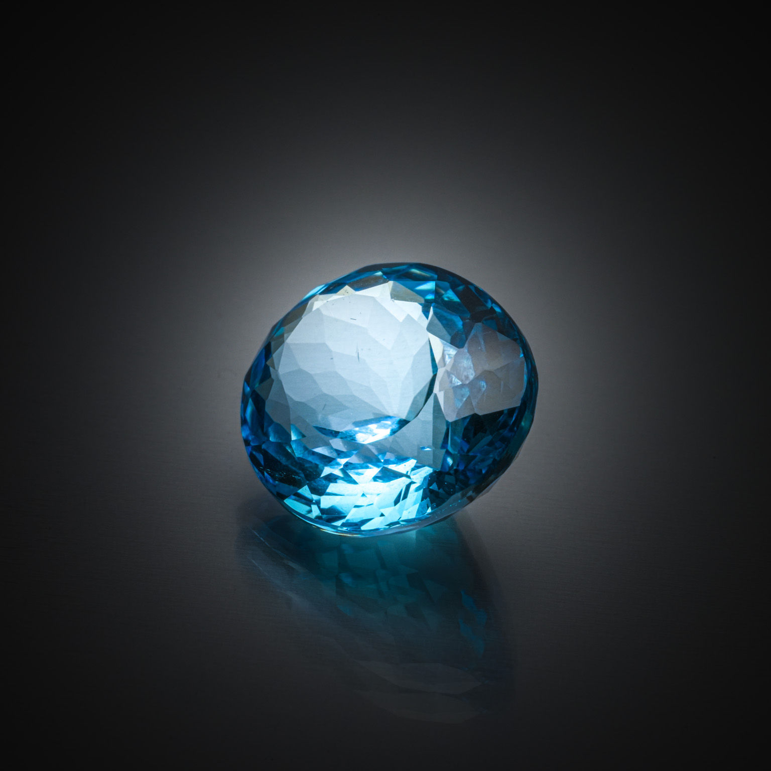 Topaze bleue (Swiss Blue) ovale sur papier. - Lazuli