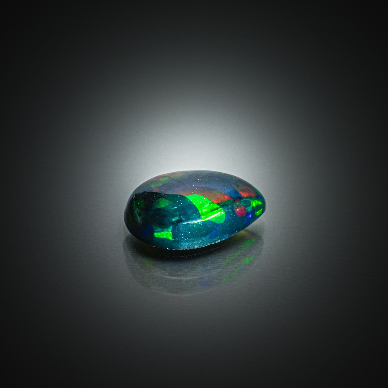 Opale noire poire cabochon sur papier. - Lazuli