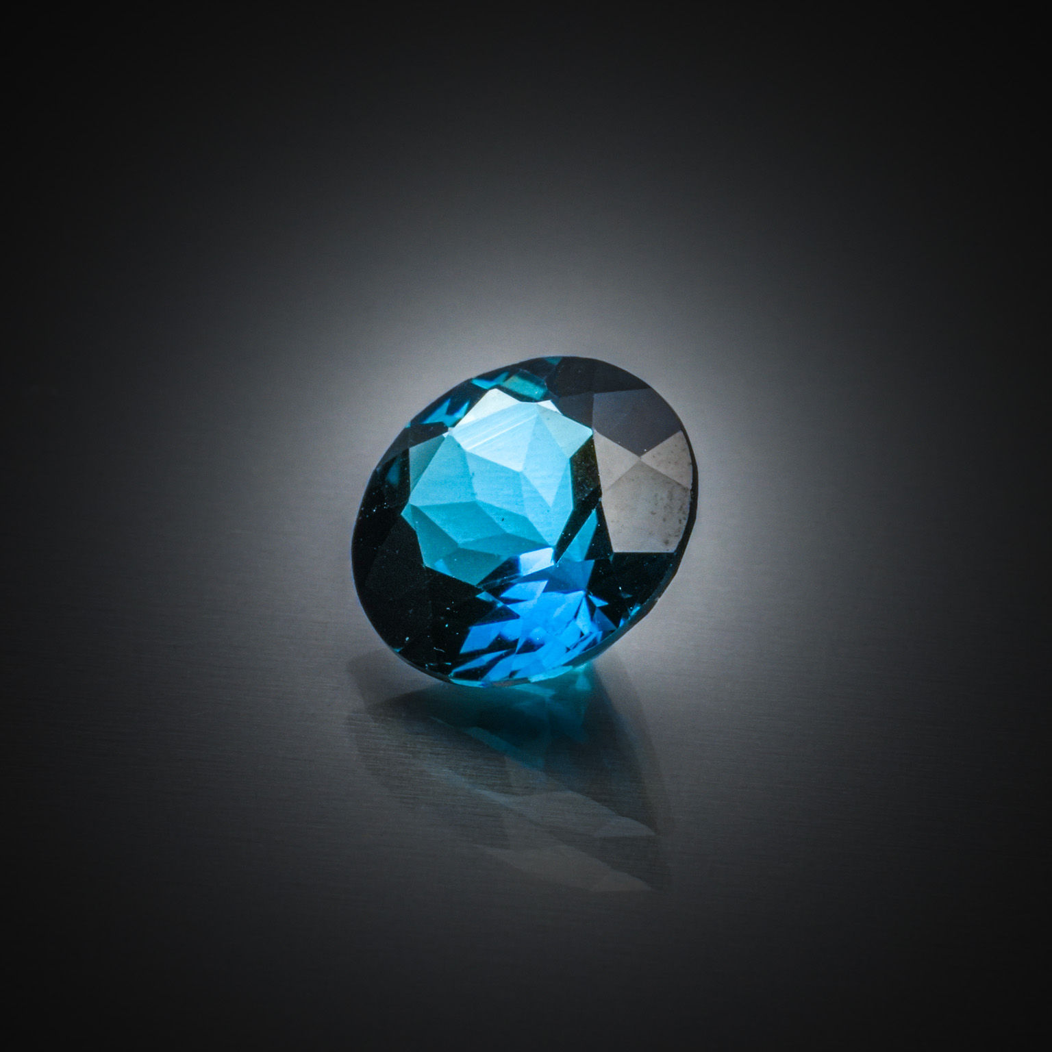 Topaze bleue (London Blue) ovale sur papier. - Lazuli