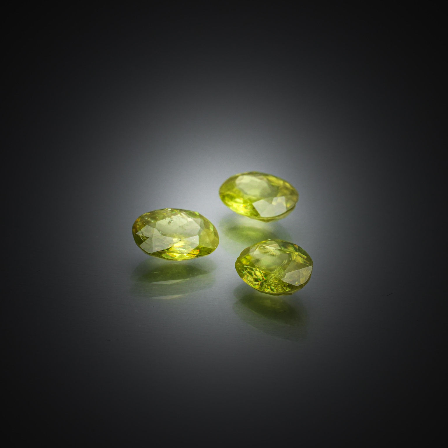 Lot de trois péridots ovales sur papier. - Lazuli