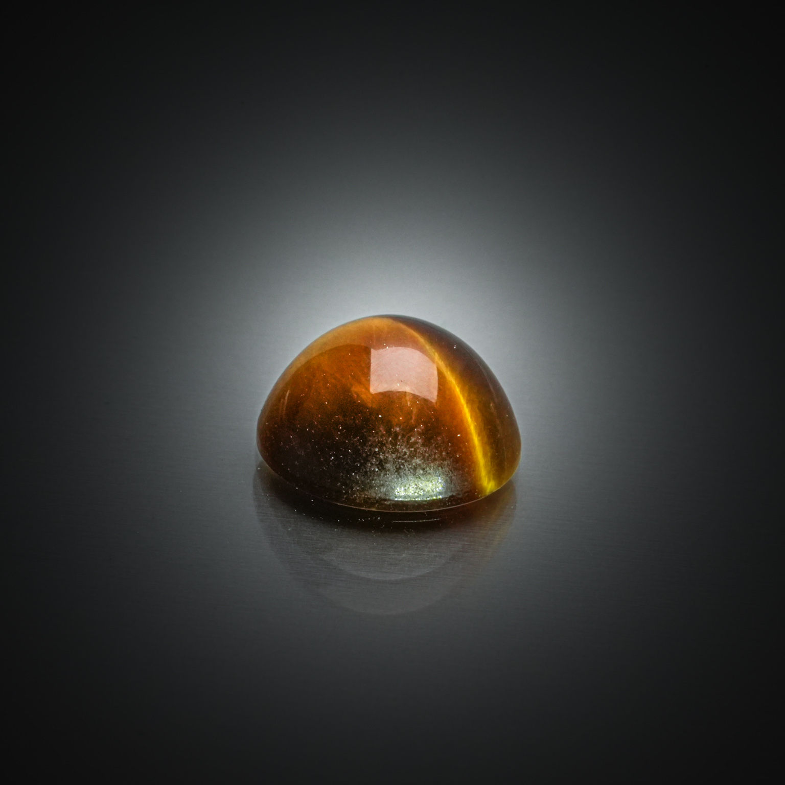 Quartz œil de tigre rond cabochon sur papier. - Lazuli