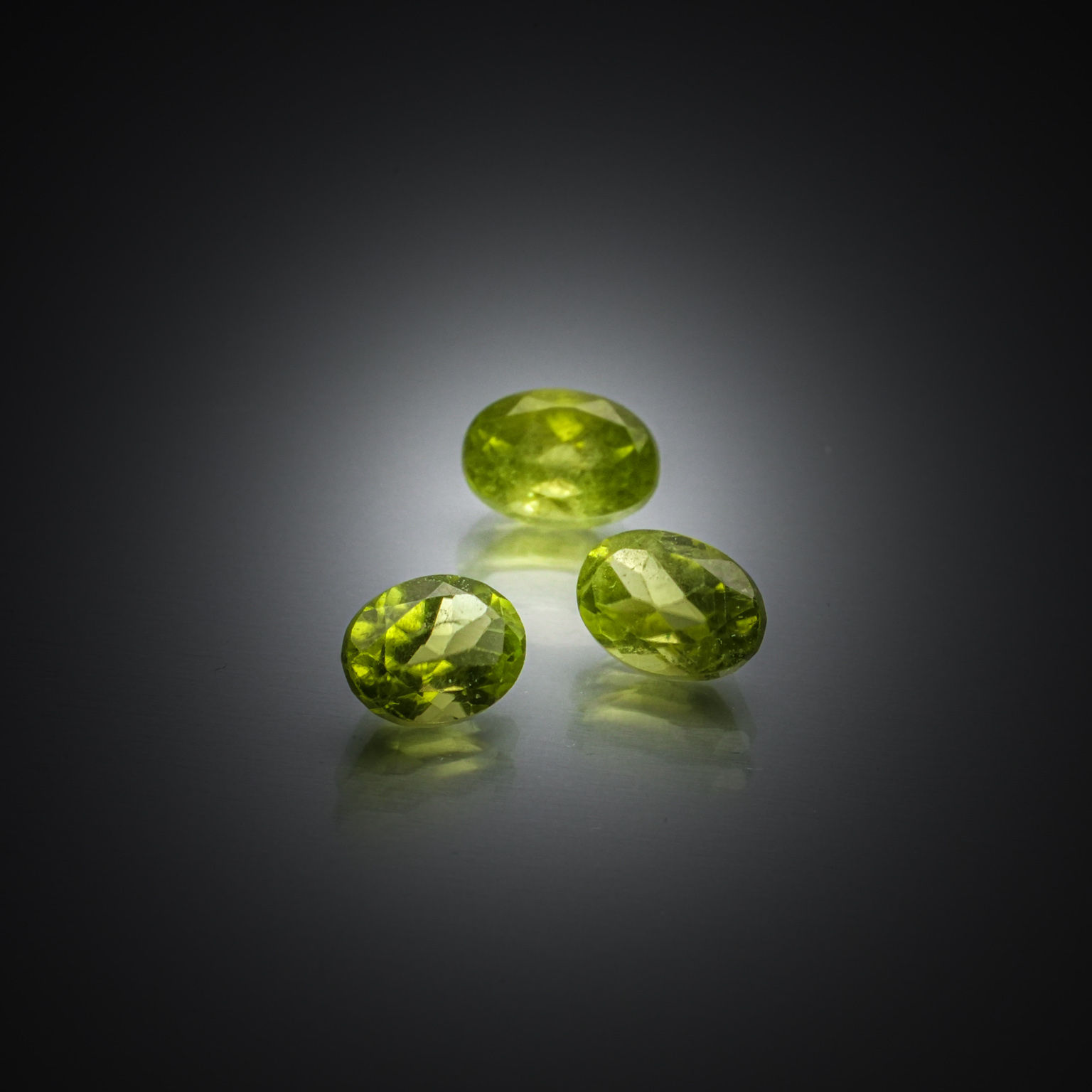 Lot de trois péridots ovales sur papier. - Lazuli