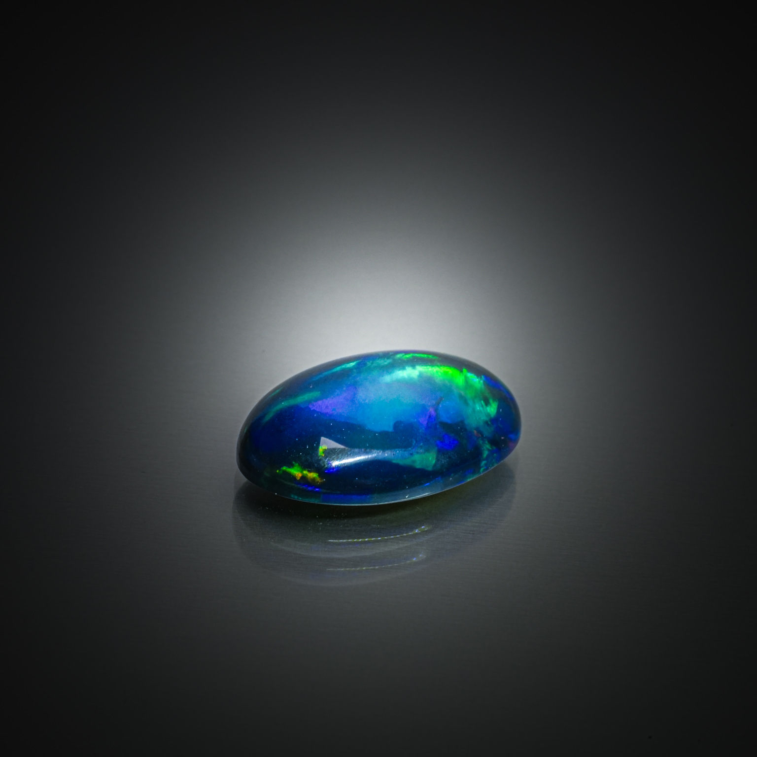 Opale noire ovale cabochon sur papier. - Lazuli