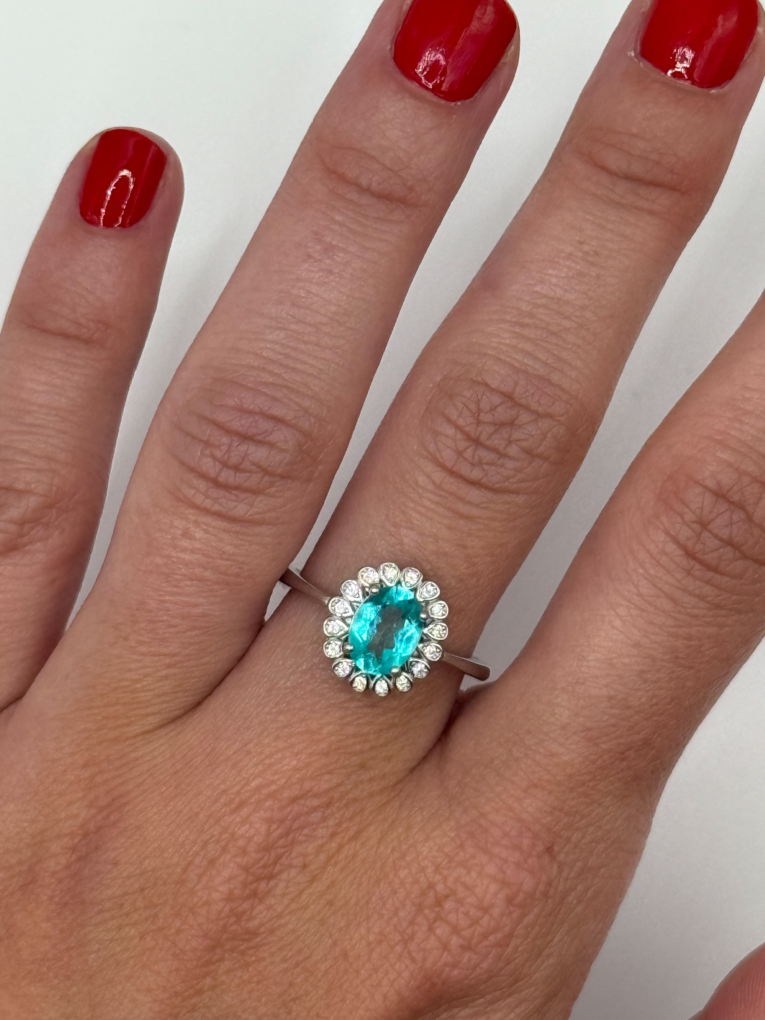 Bague en argent (925 millième) ornée d&rsquo;une topaze ovale (Paraïba Blue) dans un entourage de pierres blanches rondes. - Lazuli