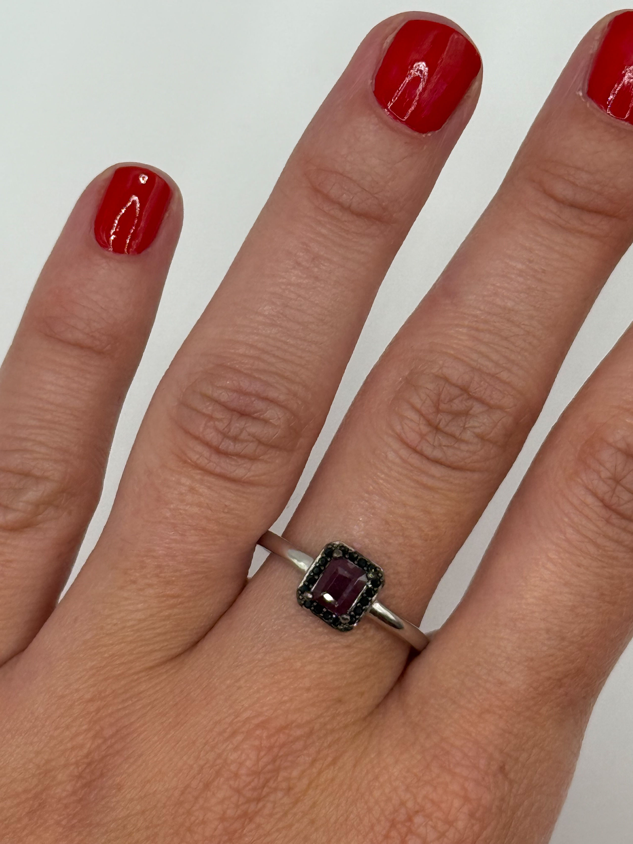 Bague en argent (925 millième) ornée d&rsquo;un rubis rectangulaire (traité) dans un entourage de spinelles noirs ronds. - Lazuli