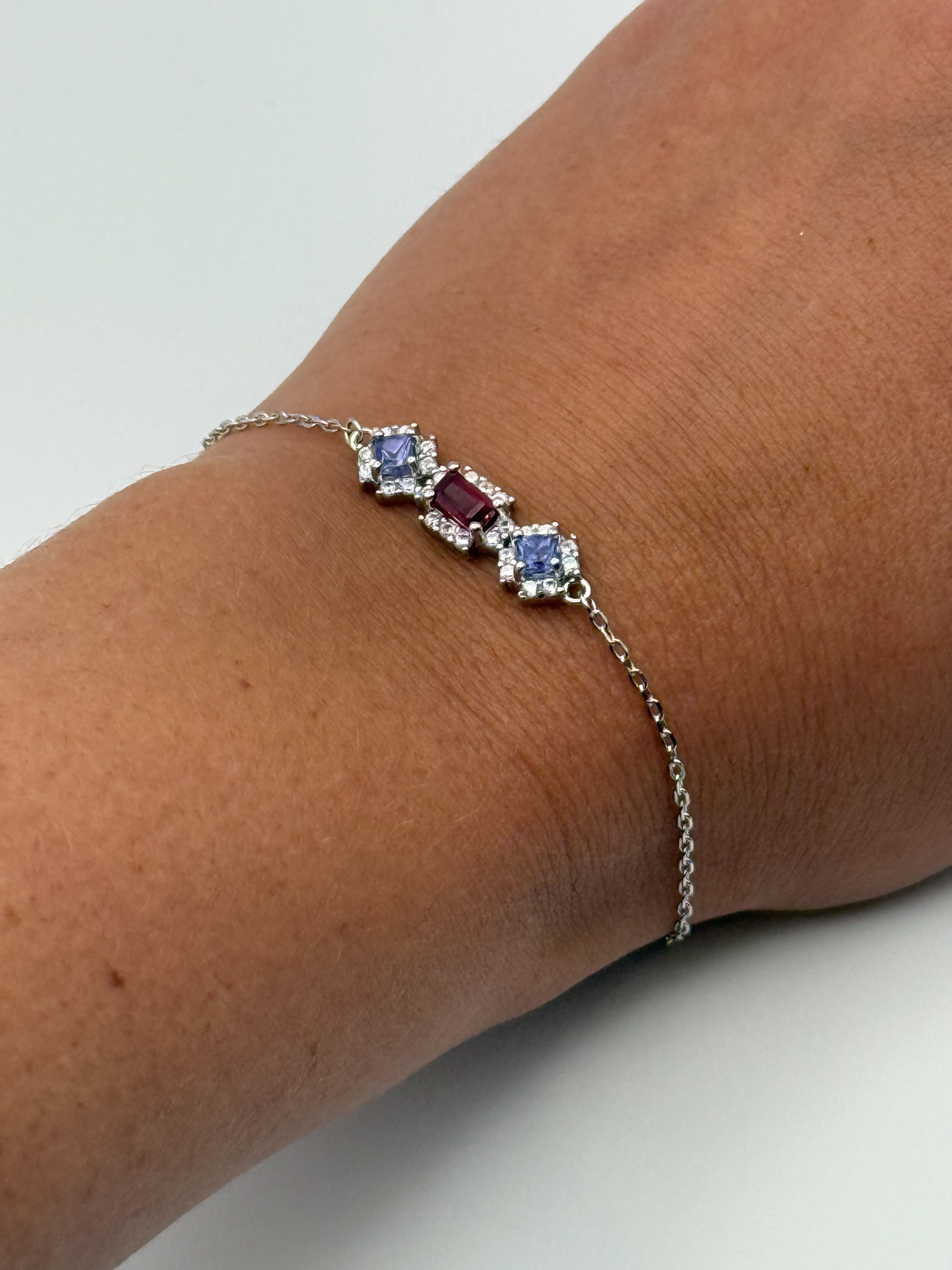 Bracelet en argent (925 millième) formé d&rsquo;une chaîne à maille forçat et orné d&rsquo;un rubis rectangulaire (traité), de deux tanzanites carrées et de pierres blanches rondes. - Lazuli