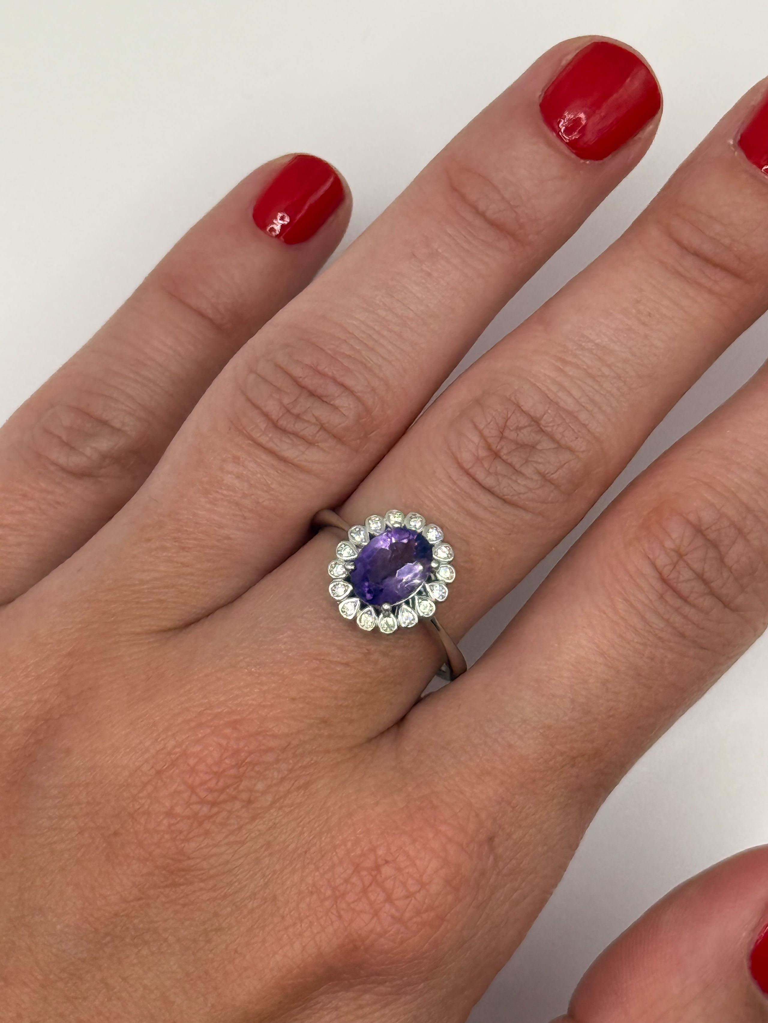 Bague marguerite en argent (925 millième) ornée dd&rsquo;une amétyste ovale dans un entourage de pierres blanches. - Lazuli