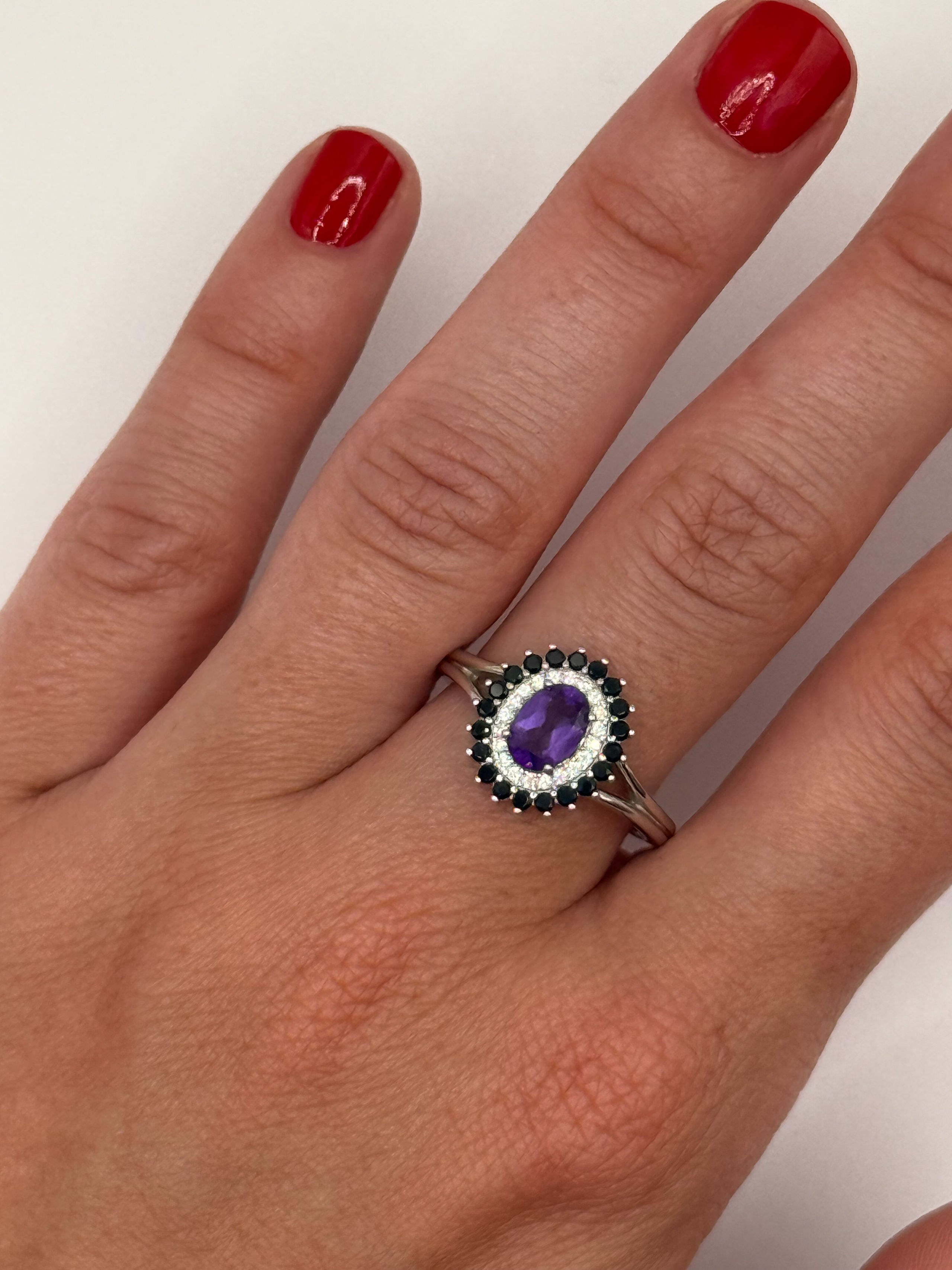 Bague en argent (925 millième) ornée d&rsquo;une améthyste ovale dans un double entourage de pierres blanches rondes et spinelles noirs ronds. - Lazuli