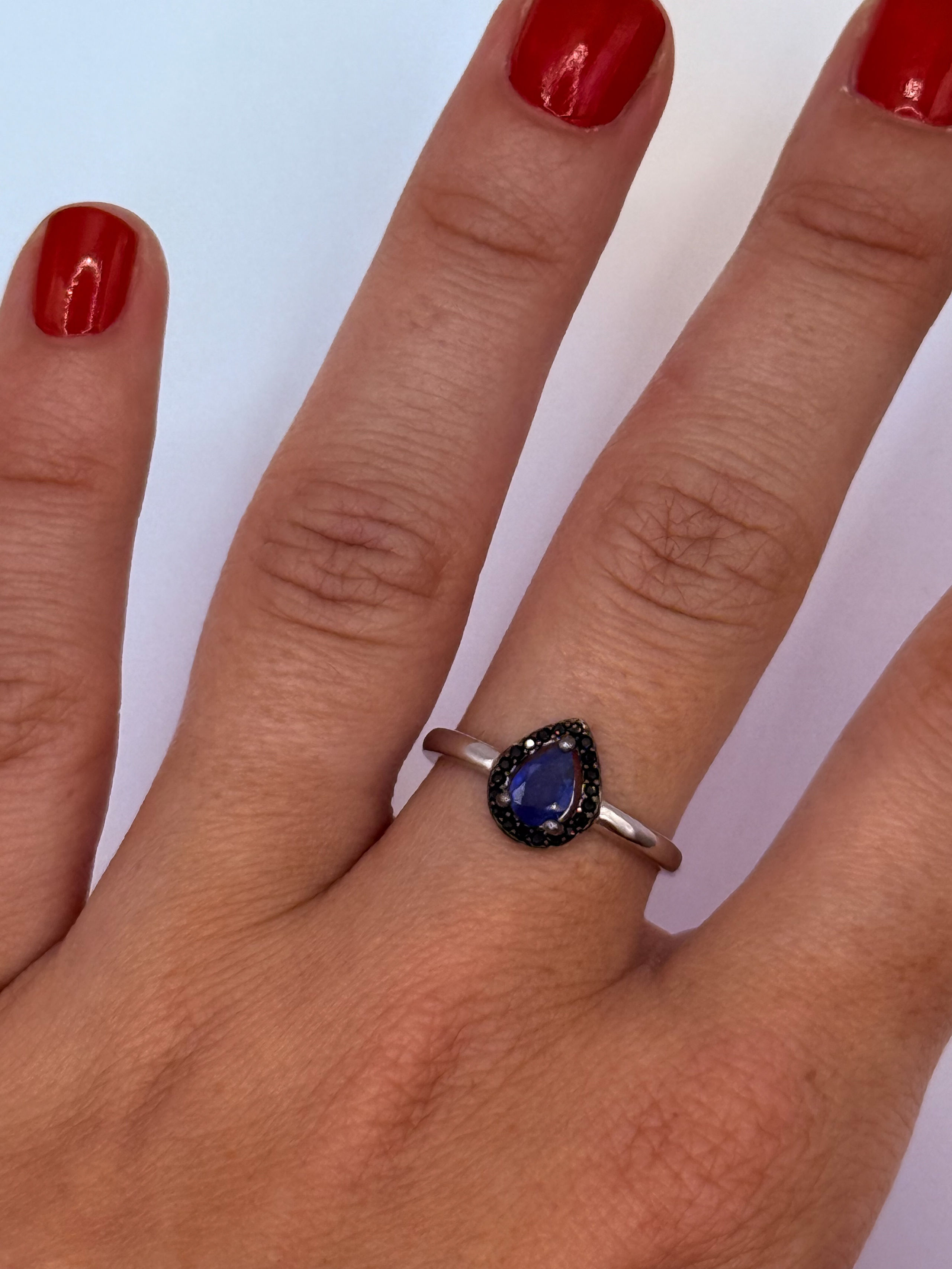 Bague en argent (925 millième) ornée d&rsquo;une topaze ovale (Paraïba Blue) dans un entourage de pierres blanches rondes. - Lazuli