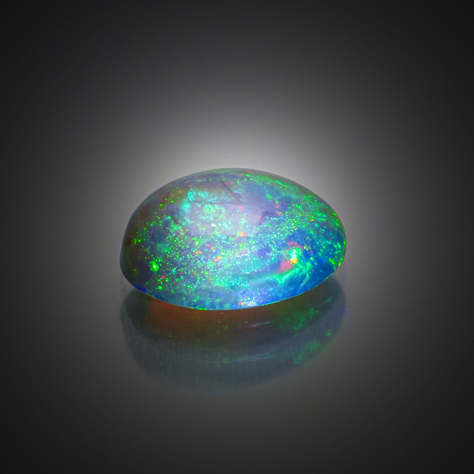Opale noire ovale cabochon sur papier. - Lazuli