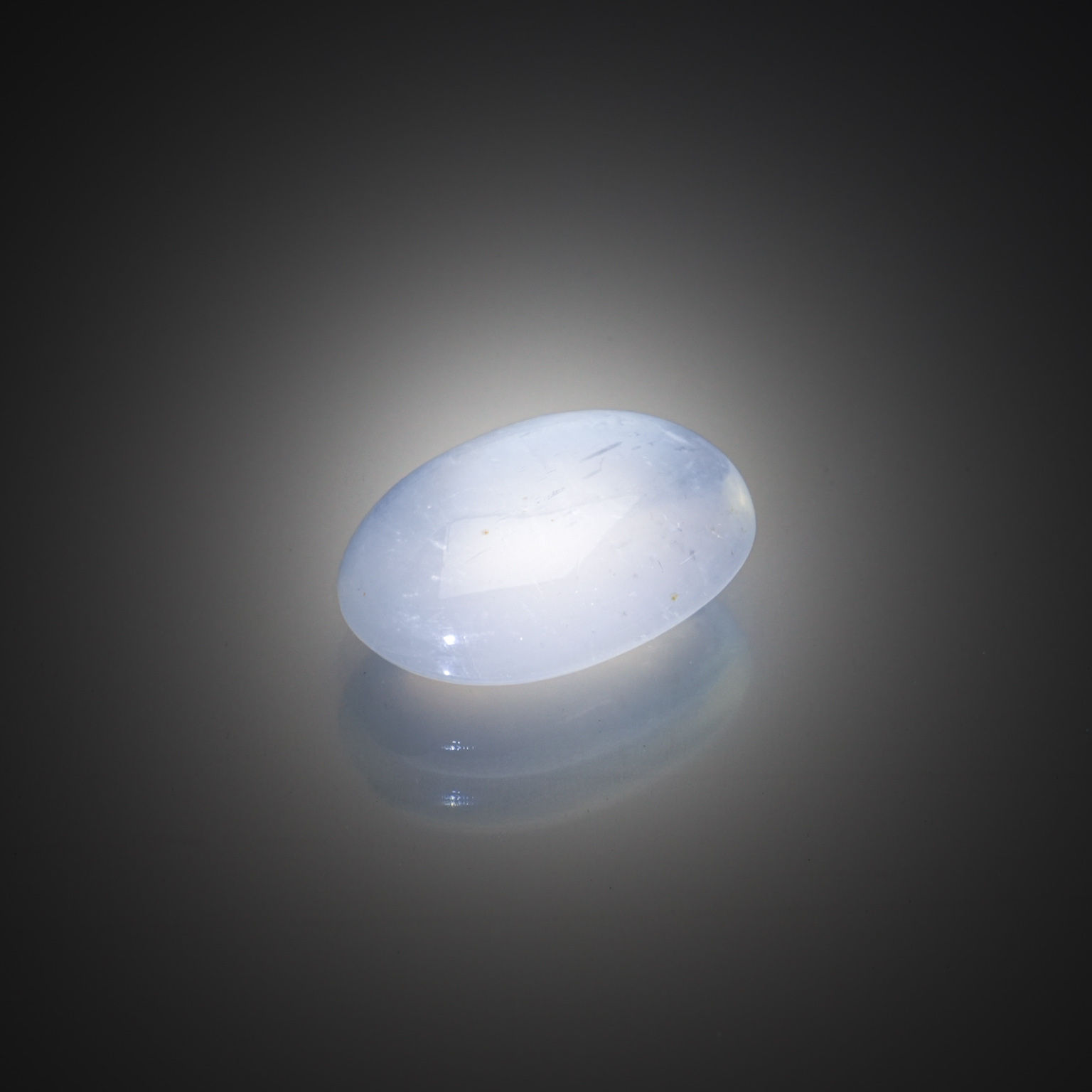 Pierre de lune ovale cabochon sur papier. - Lazuli