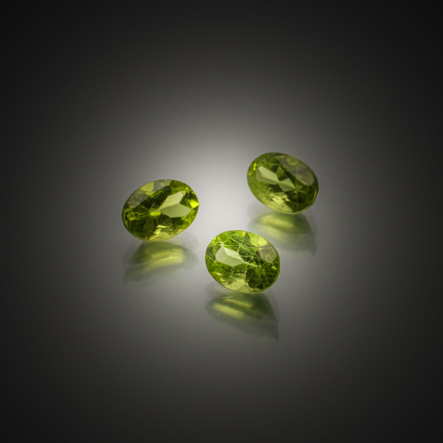 Lot de trois péridots ovales sur papier. - Lazuli