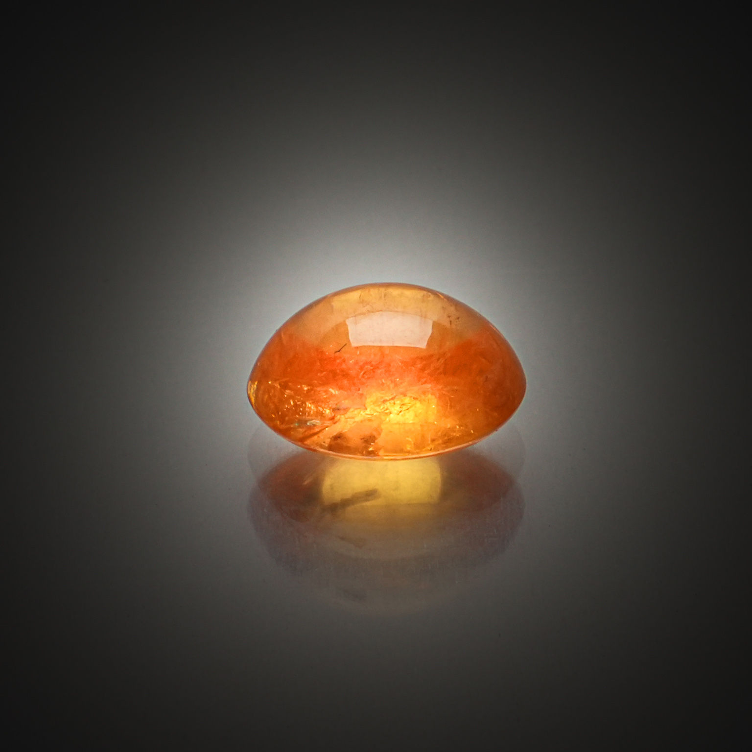 Grenat spessartite ovale cabochon sur papier. - Lazuli