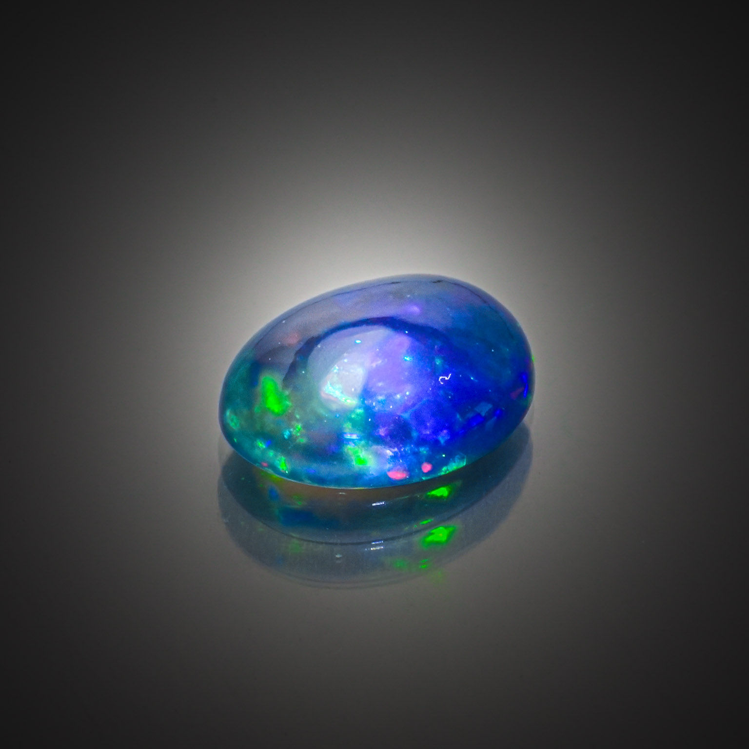 Opale noire ovale cabochon sur papier. - Lazuli