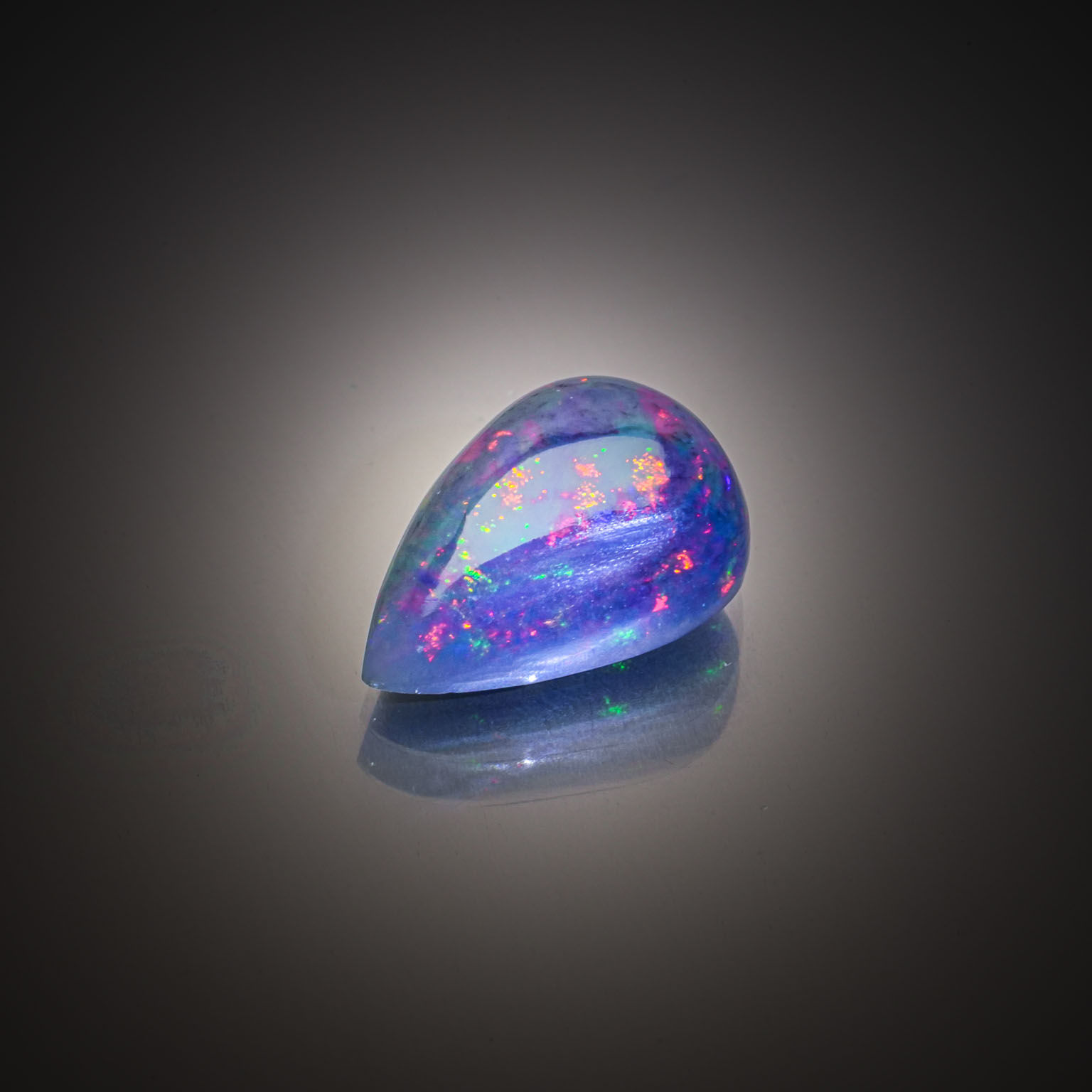 Opale noire cabochon sur papier. - Lazuli