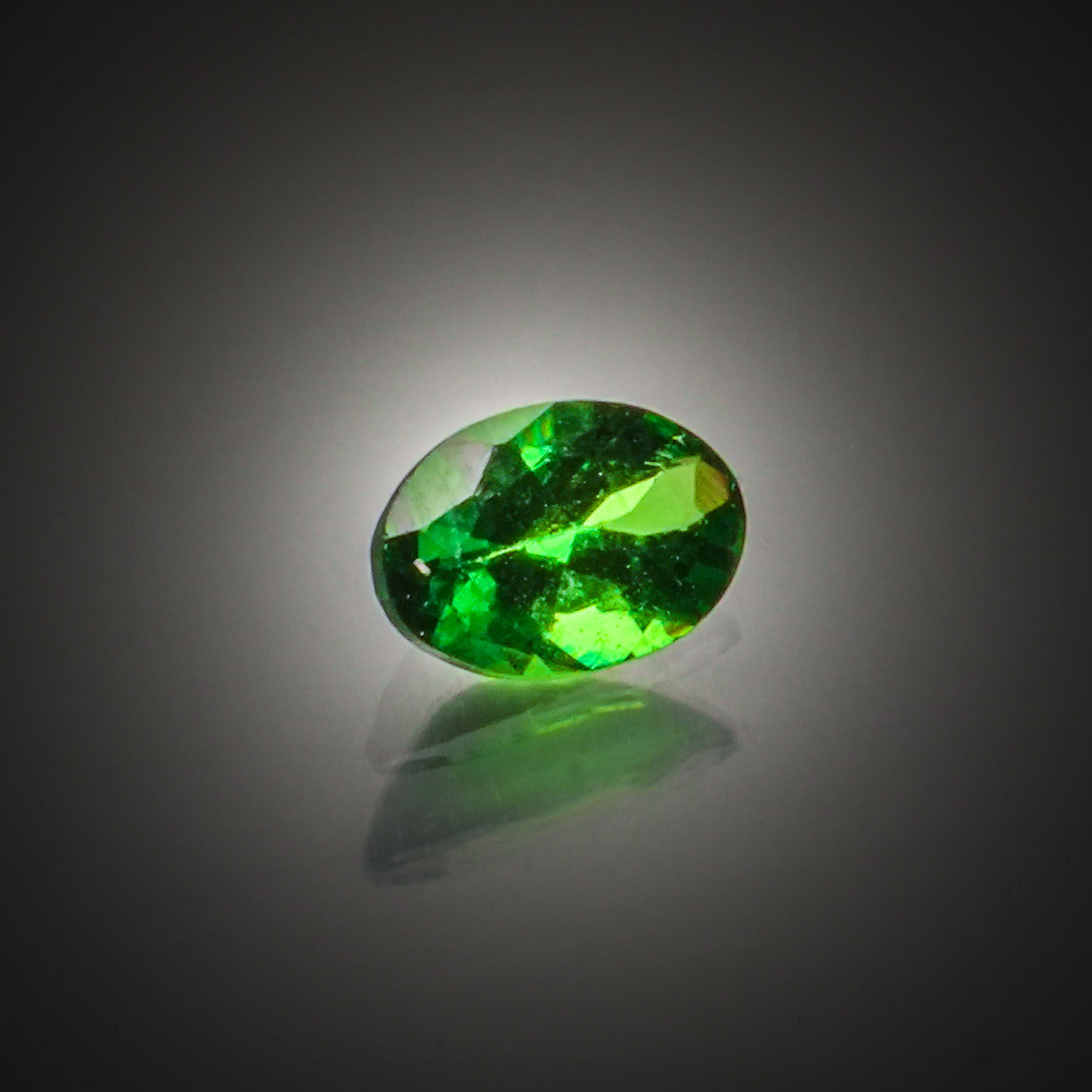 Grenat tsavorite ovale sur papier. - Lazuli