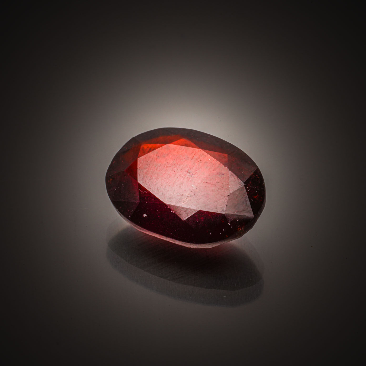 Grenat spessartite ovale cabochon sur papier. - Lazuli