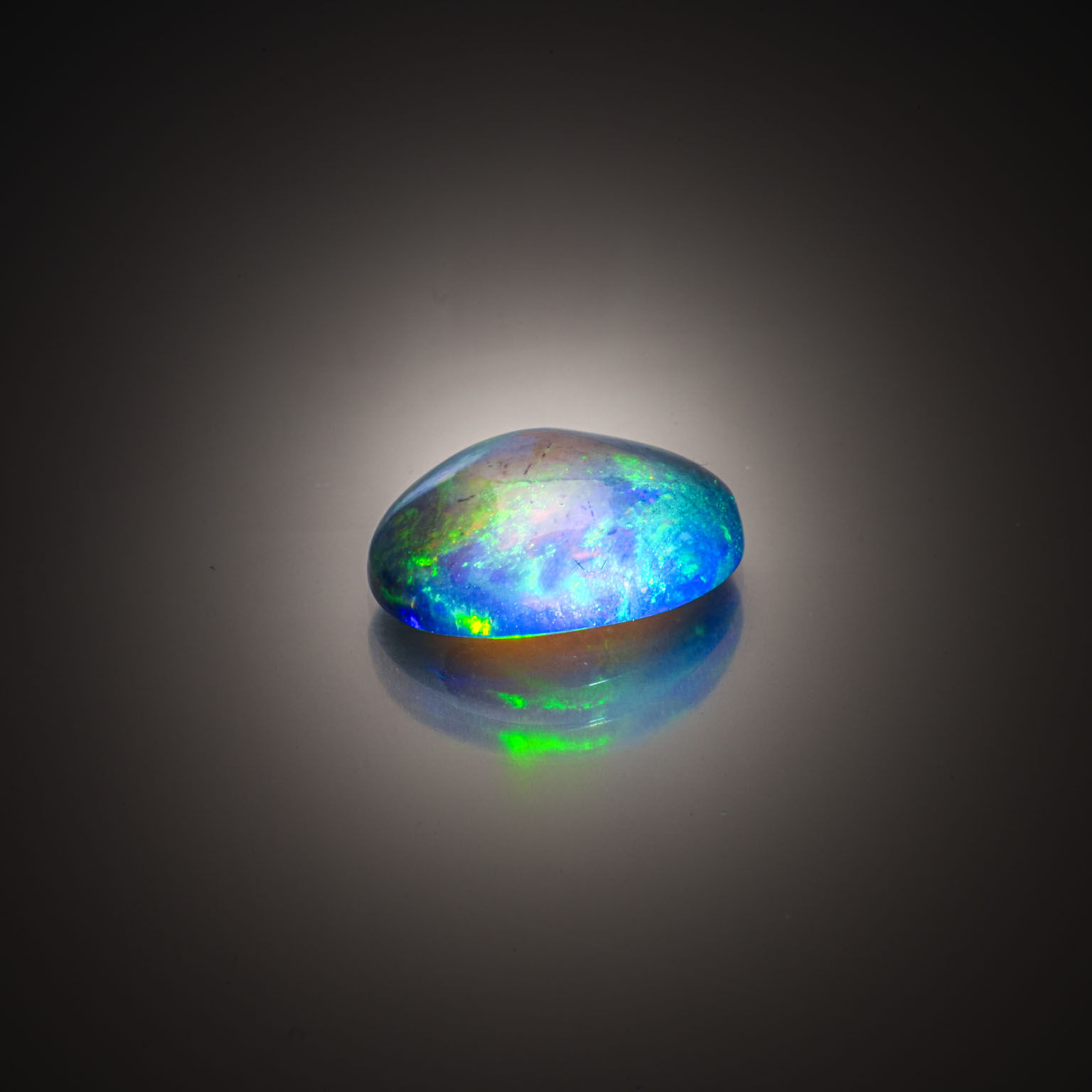 Opale noire ovale cabochon sur papier. - Lazuli