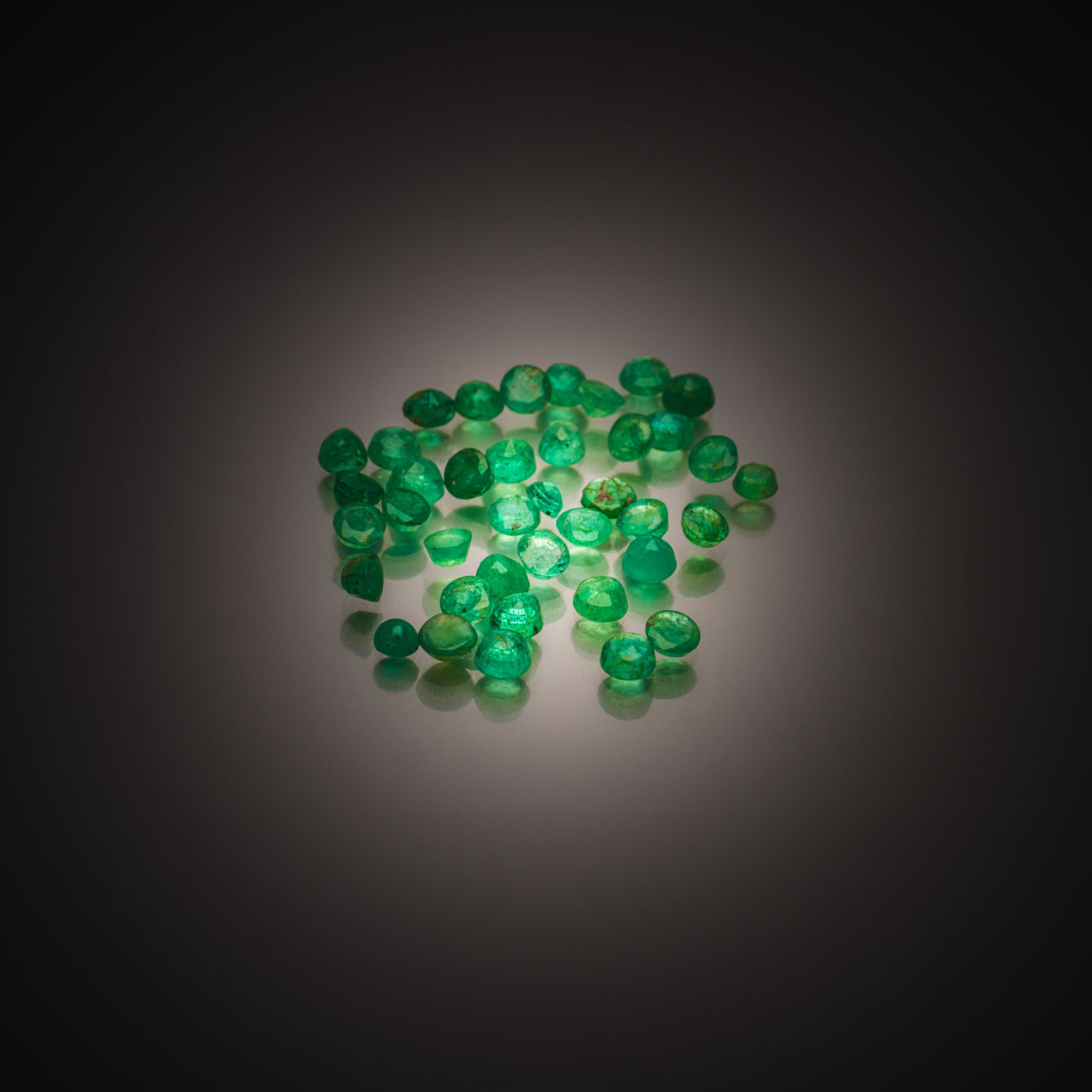 Lot d&rsquo;émeraudes rondes sur papier. - Lazuli