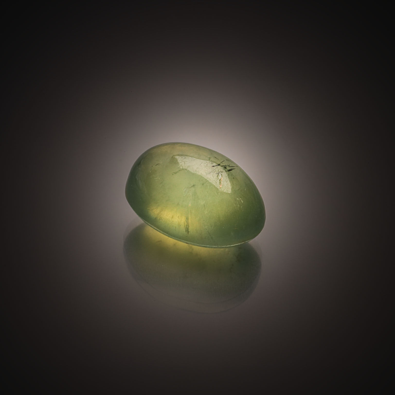 Scapolite œil-de-chat ovale cabochon sur papier. - Lazuli