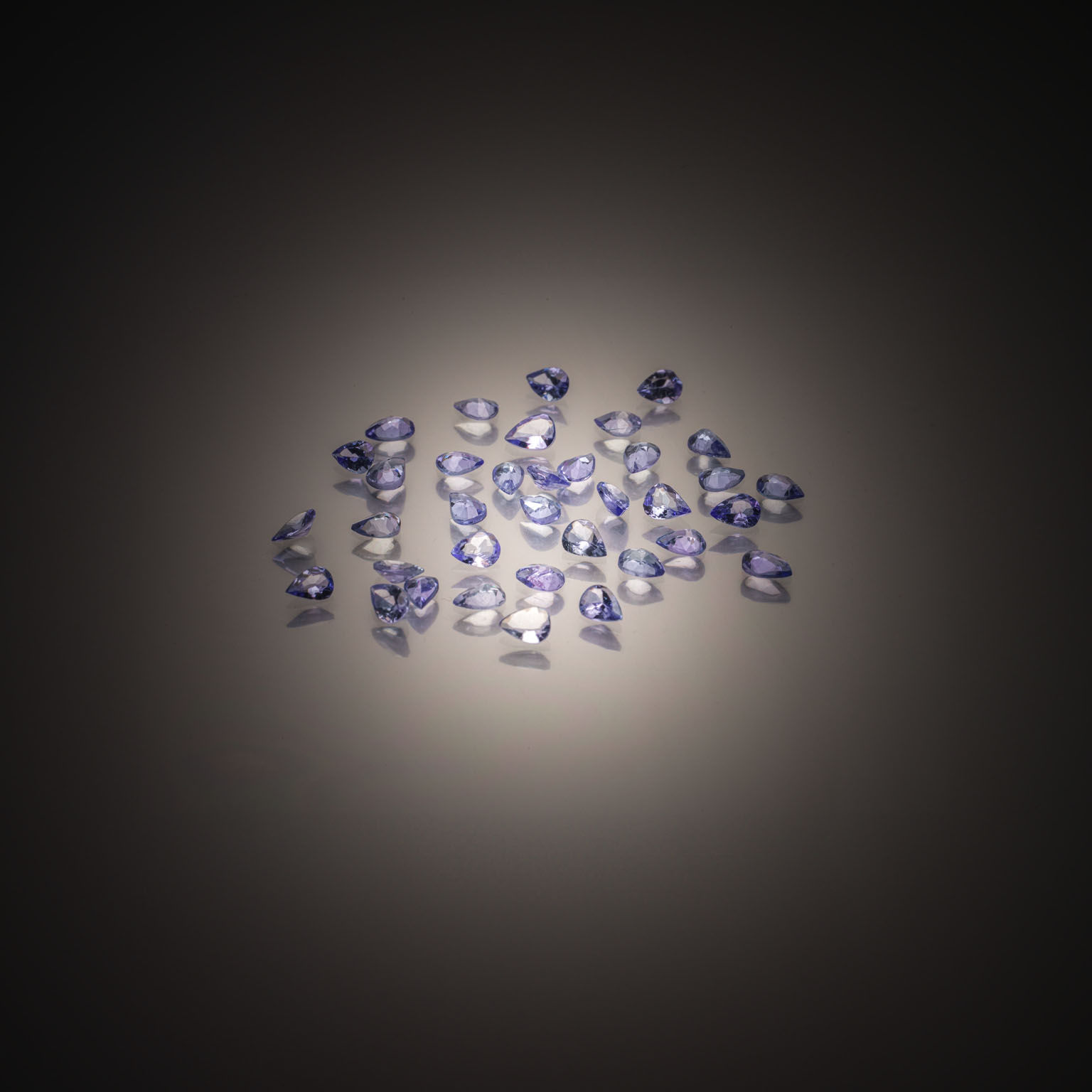 Topaze bleue briolette sur papier. - Lazuli