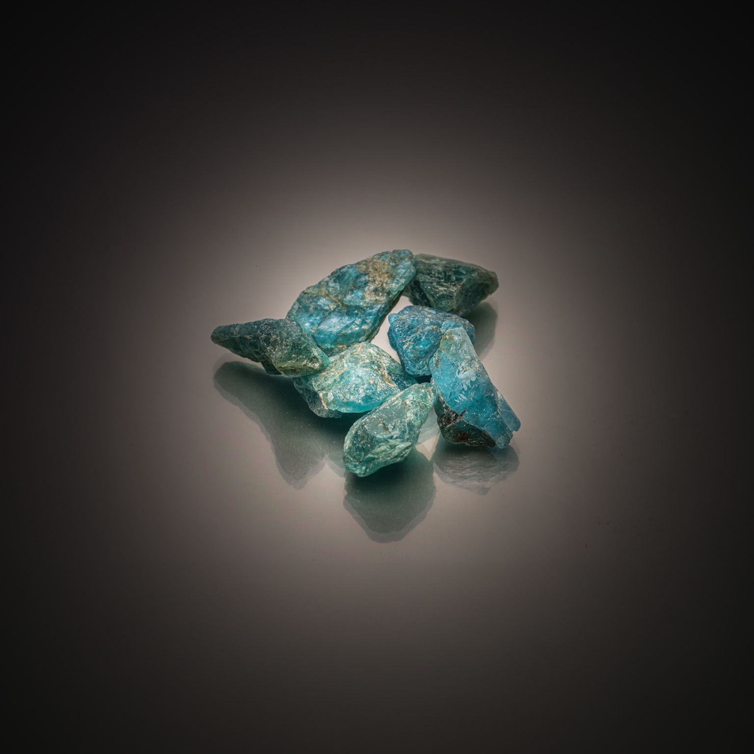 Lot de sept apatites bleues brutes sur papier. - Lazuli