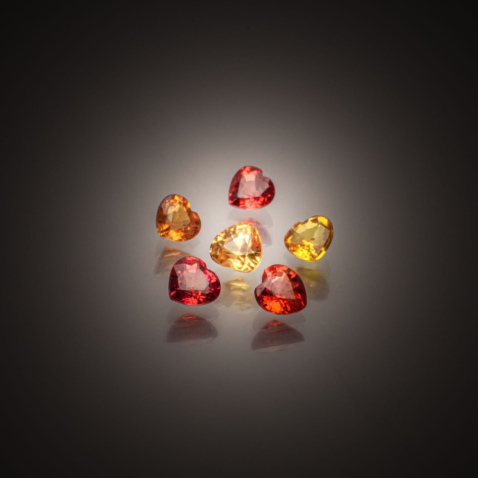 Lot de six saphirs orange et jaunes coeurs sur papier. - Lazuli