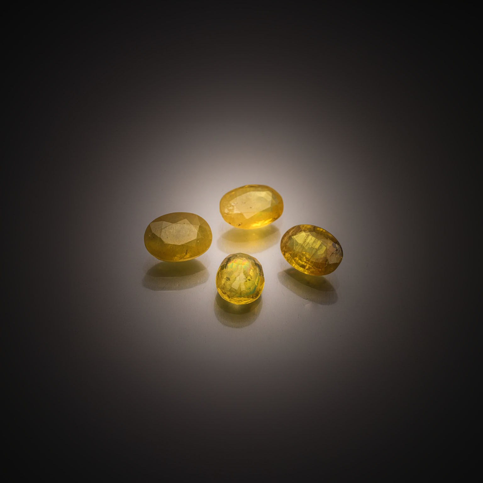 Lot de onze saphirs jaunes et oranges triangulaires sur papier. - Lazuli