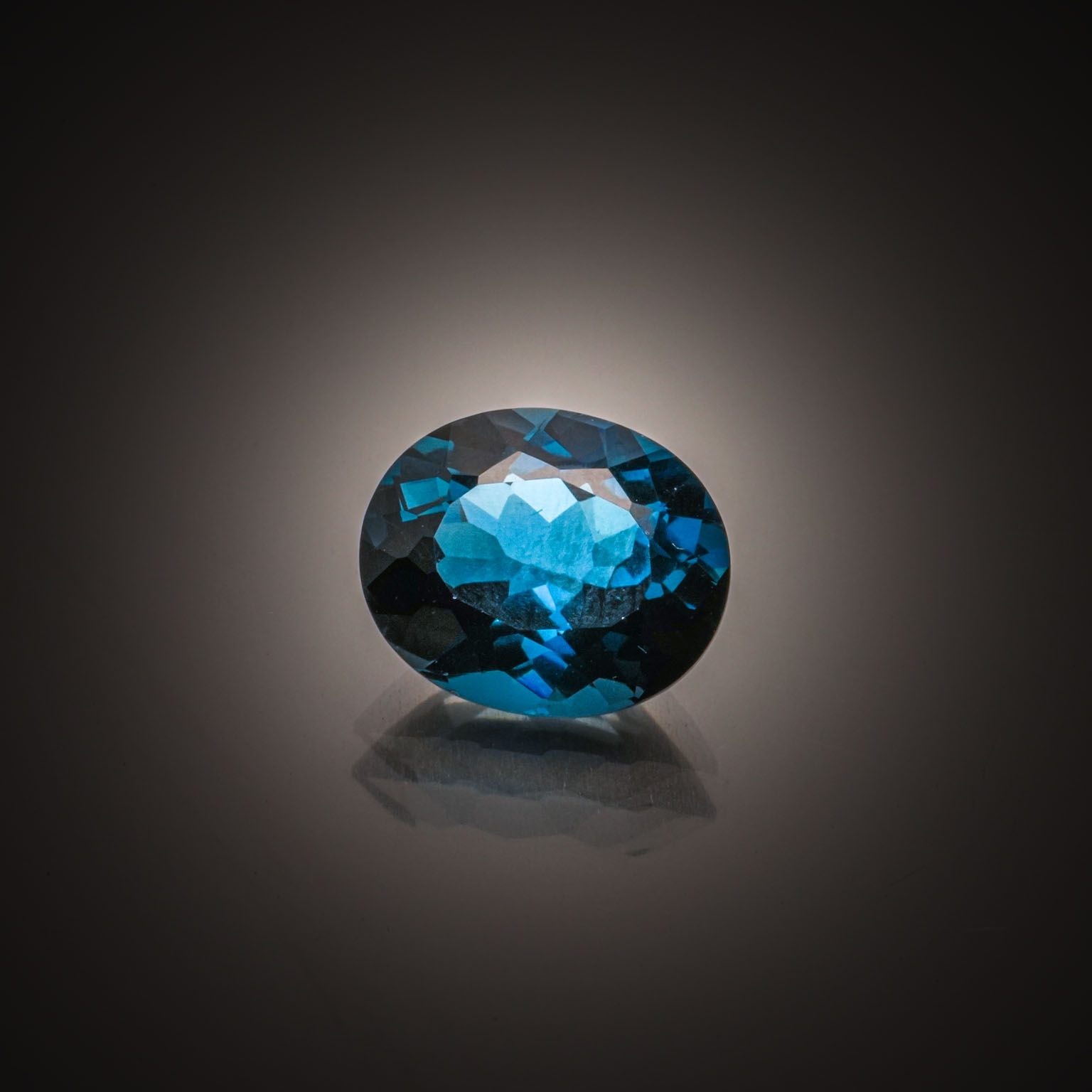 Topaze bleue (London Blue) ovale sur papier. - Lazuli