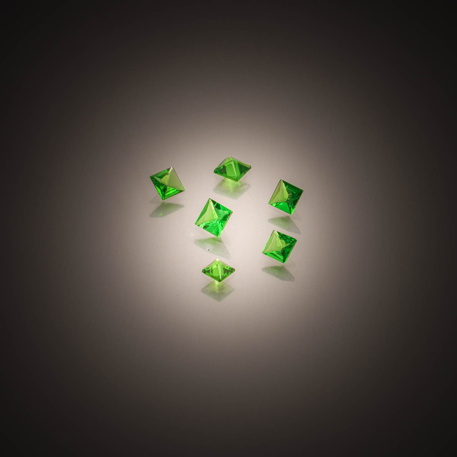 Lot de six grenats tsavorites carrés sur papier. - Lazuli
