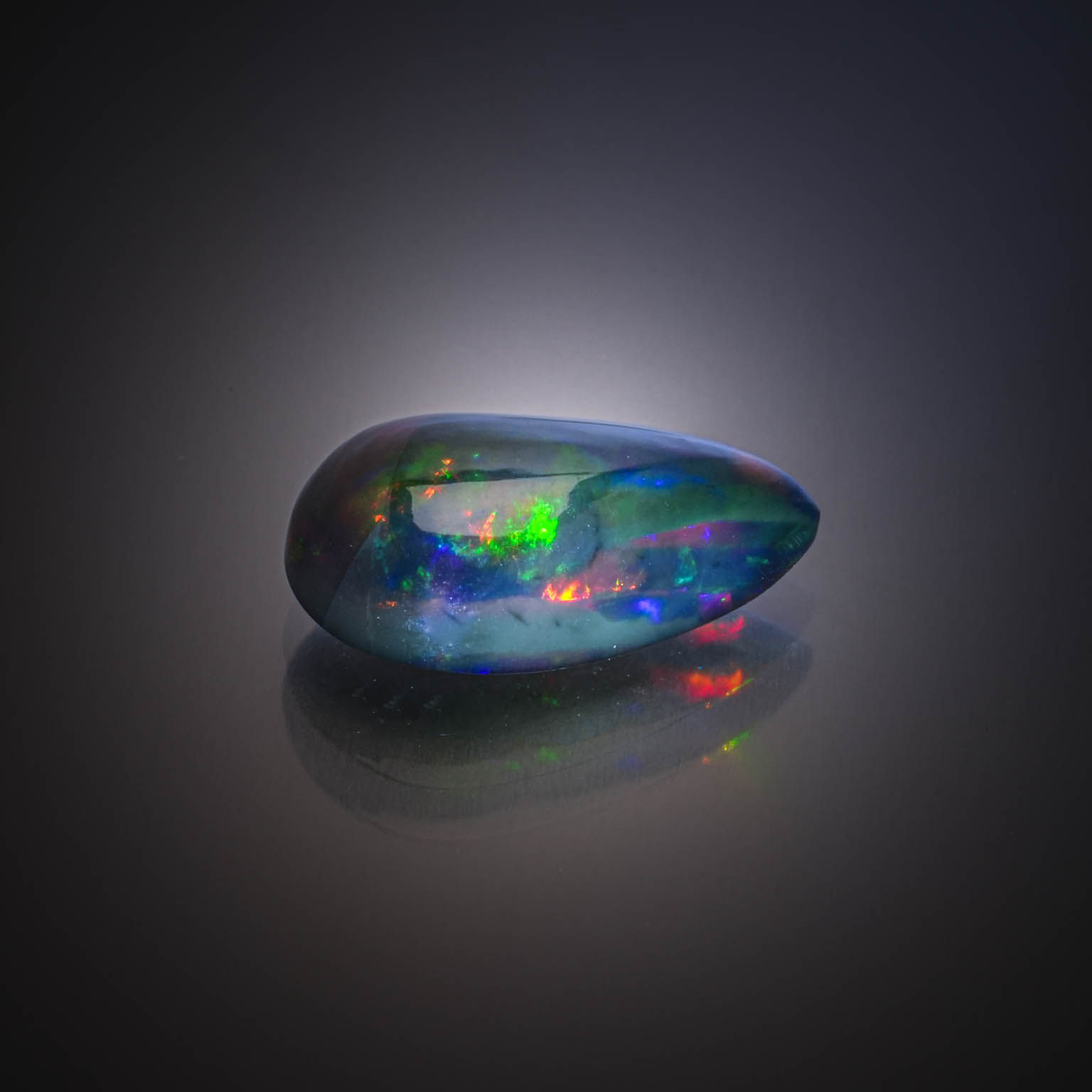 Opale noire poire cabochon sur papier. - Lazuli