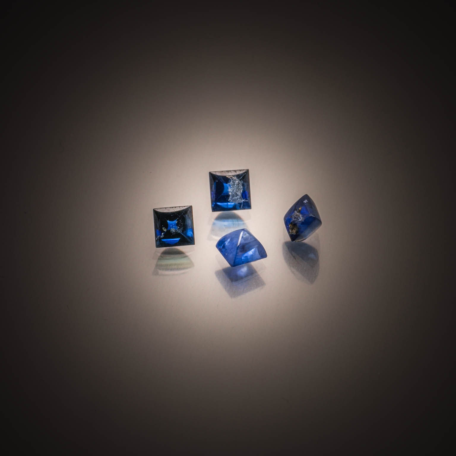 Lot de quatre saphirs carrés sur papier. - Lazuli