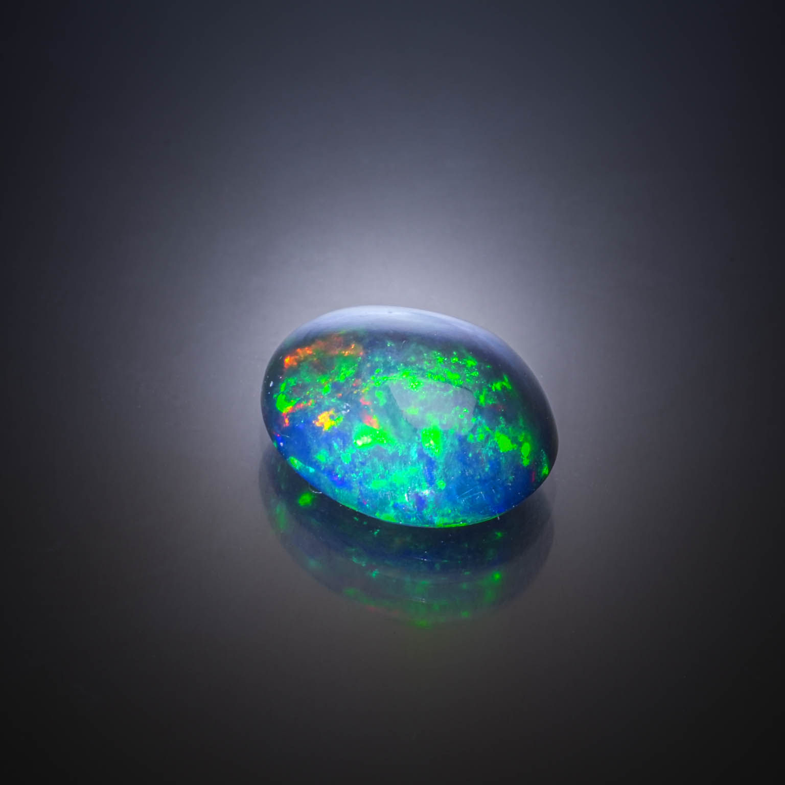 Opale noire ovale cabochon sur papier. - Lazuli