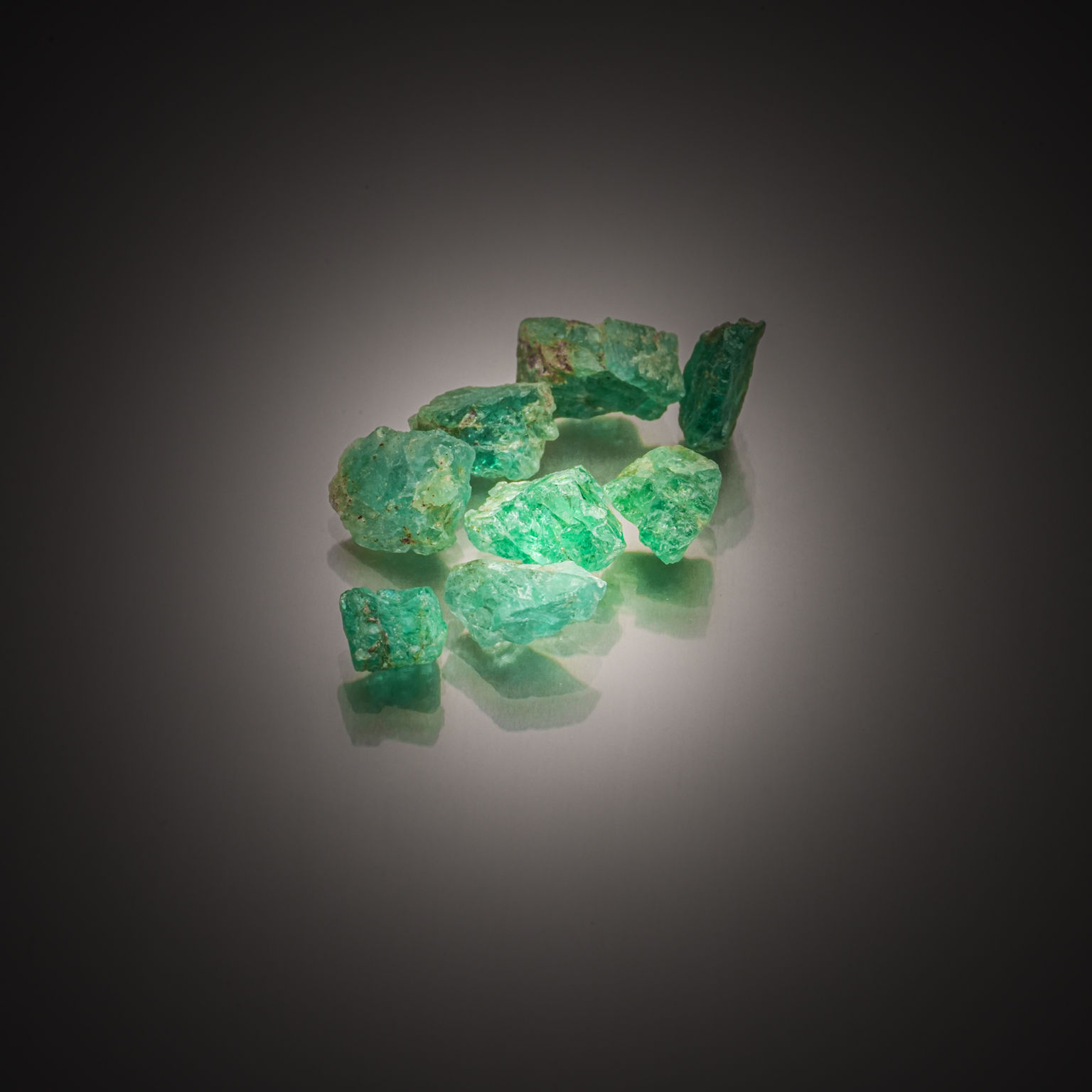 Lot de huit émeraudes brutes sur papier. - Lazuli