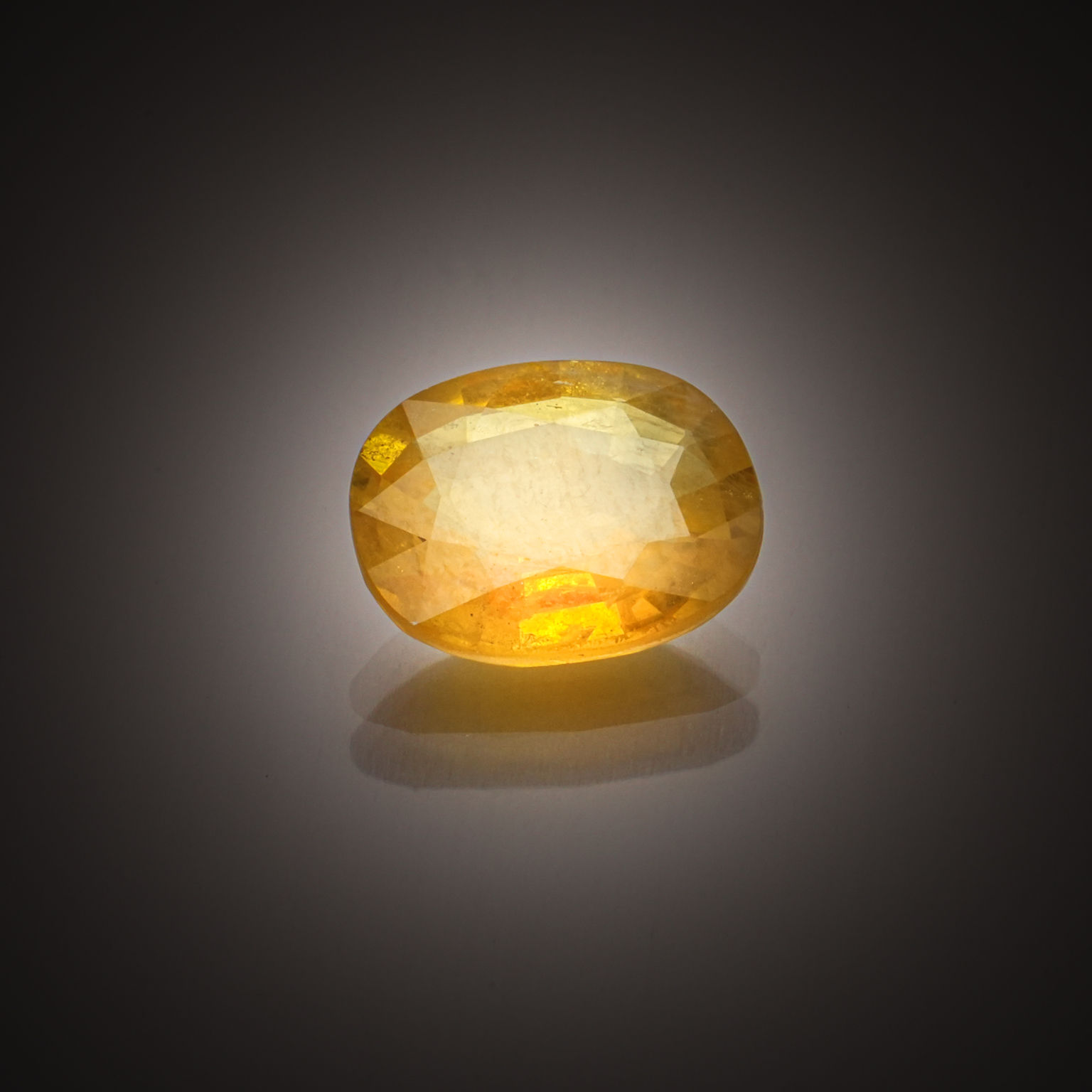 Saphir jaune ovale sur papier. - Lazuli