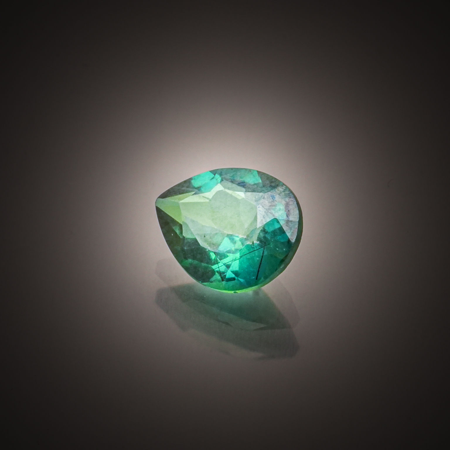 Topaze verte poire sur papier. - Lazuli