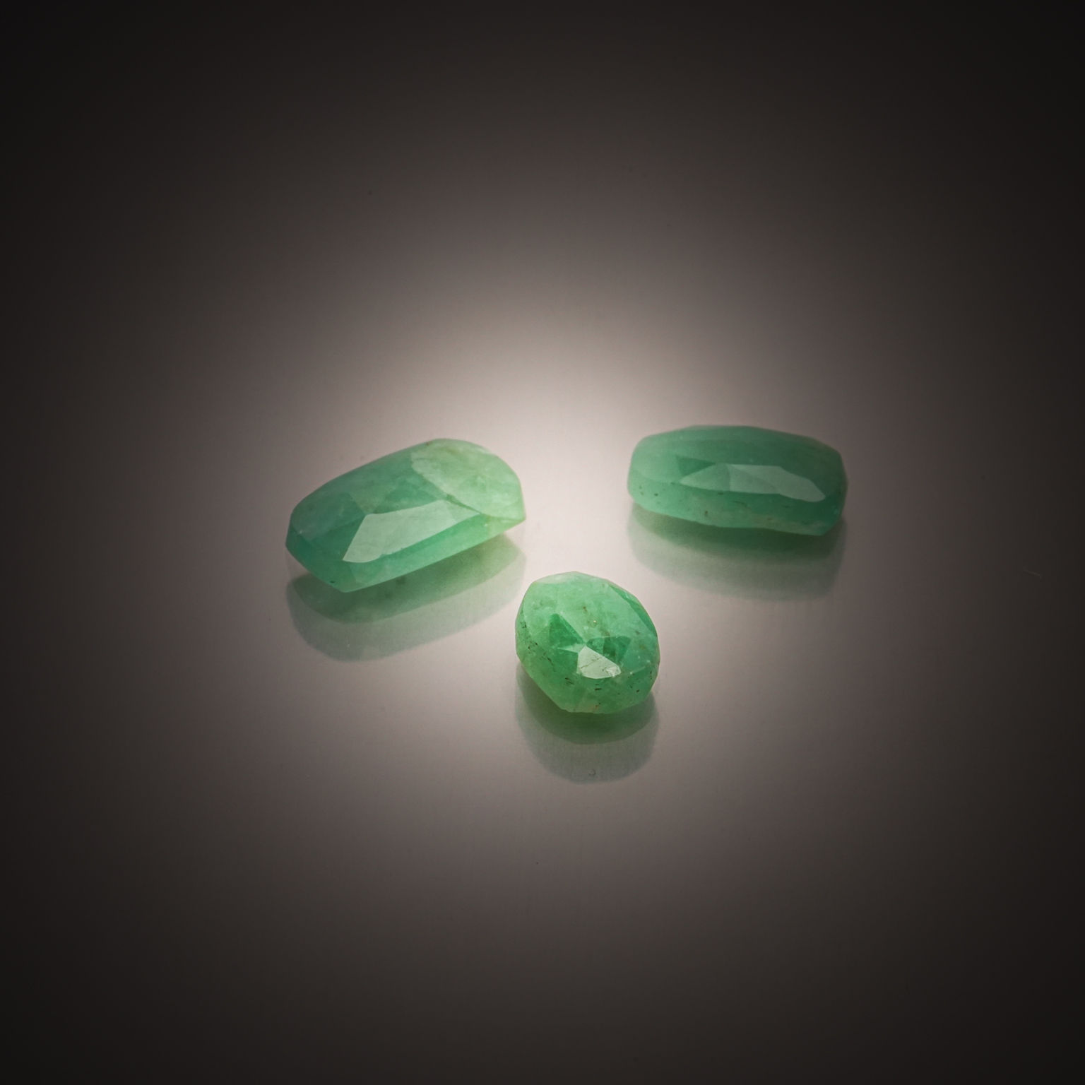 Lot de trois émeraudes coussins et ovale sur papier. - Lazuli