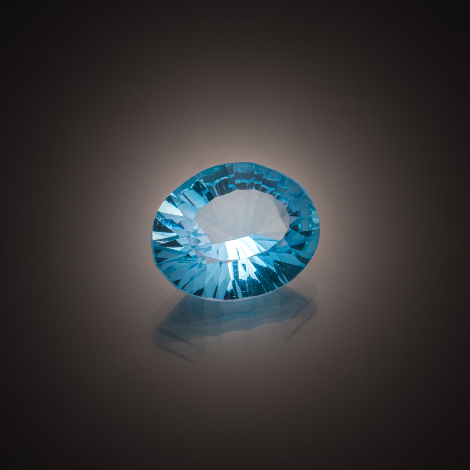 Topaze bleue ovale concave sur papier. - Lazuli