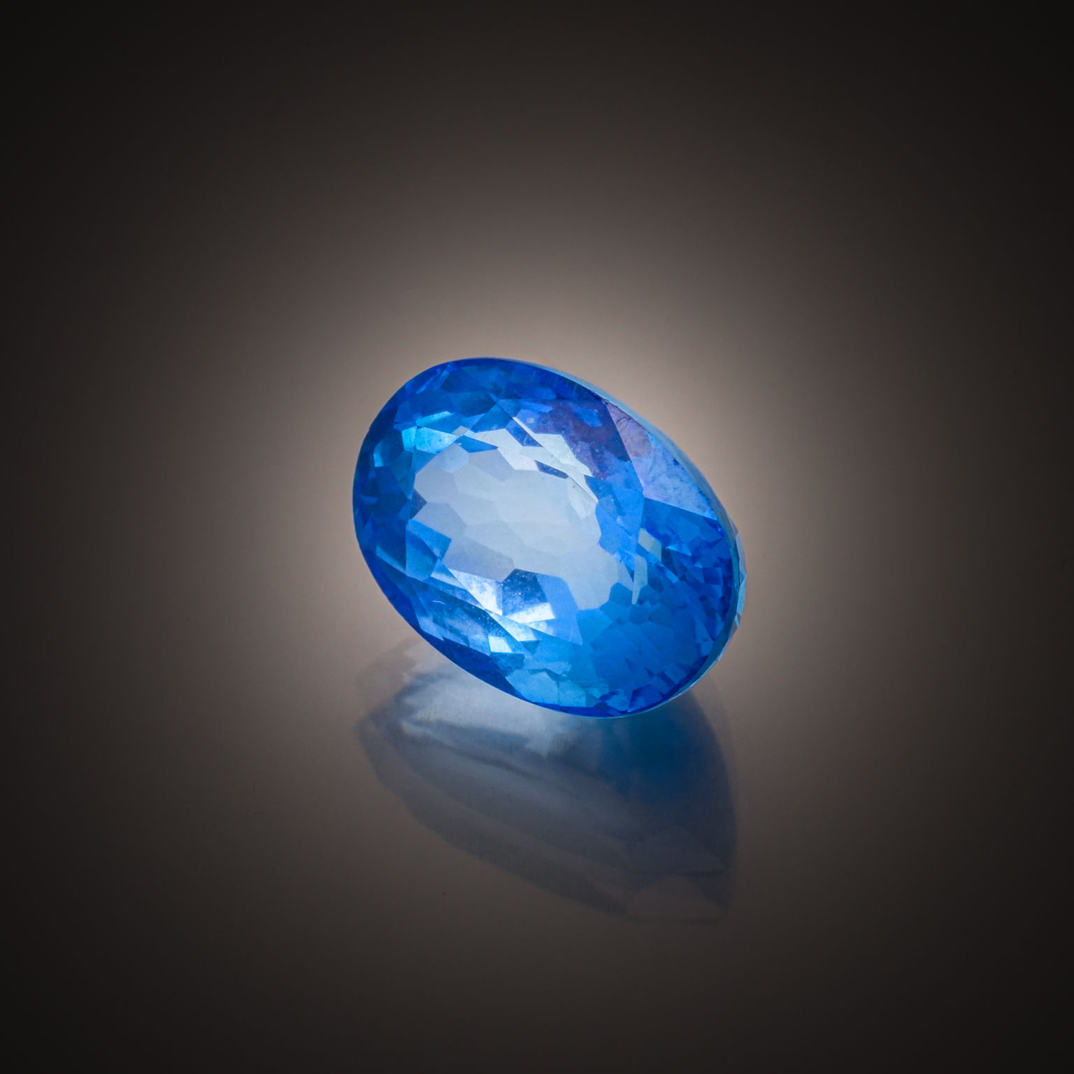 Topaze bleue ovale sur papier. - Lazuli