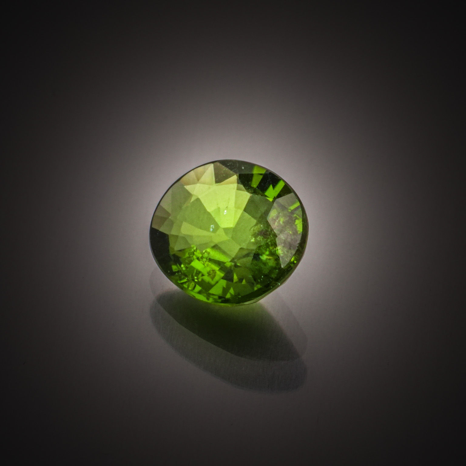 Grenat tsavorite ovale sur papier. - Lazuli
