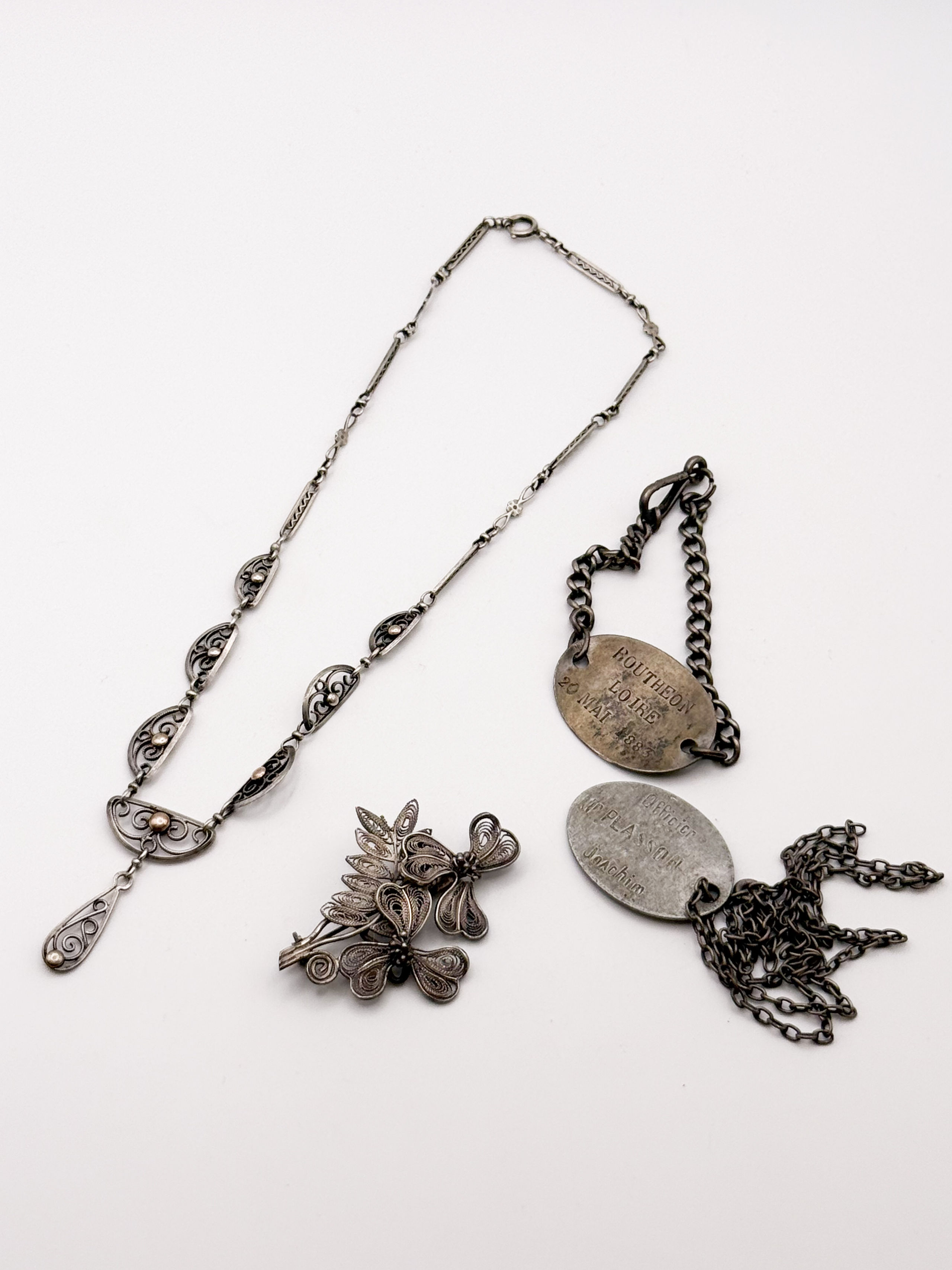 Lot en argent comprenant deux colliers à médaillon ajouré représentant des dragons (accidents), une bague décor de croissants et une bague ornée d&rsquo;une pierre imitation et pierres blanches. - Lazuli
